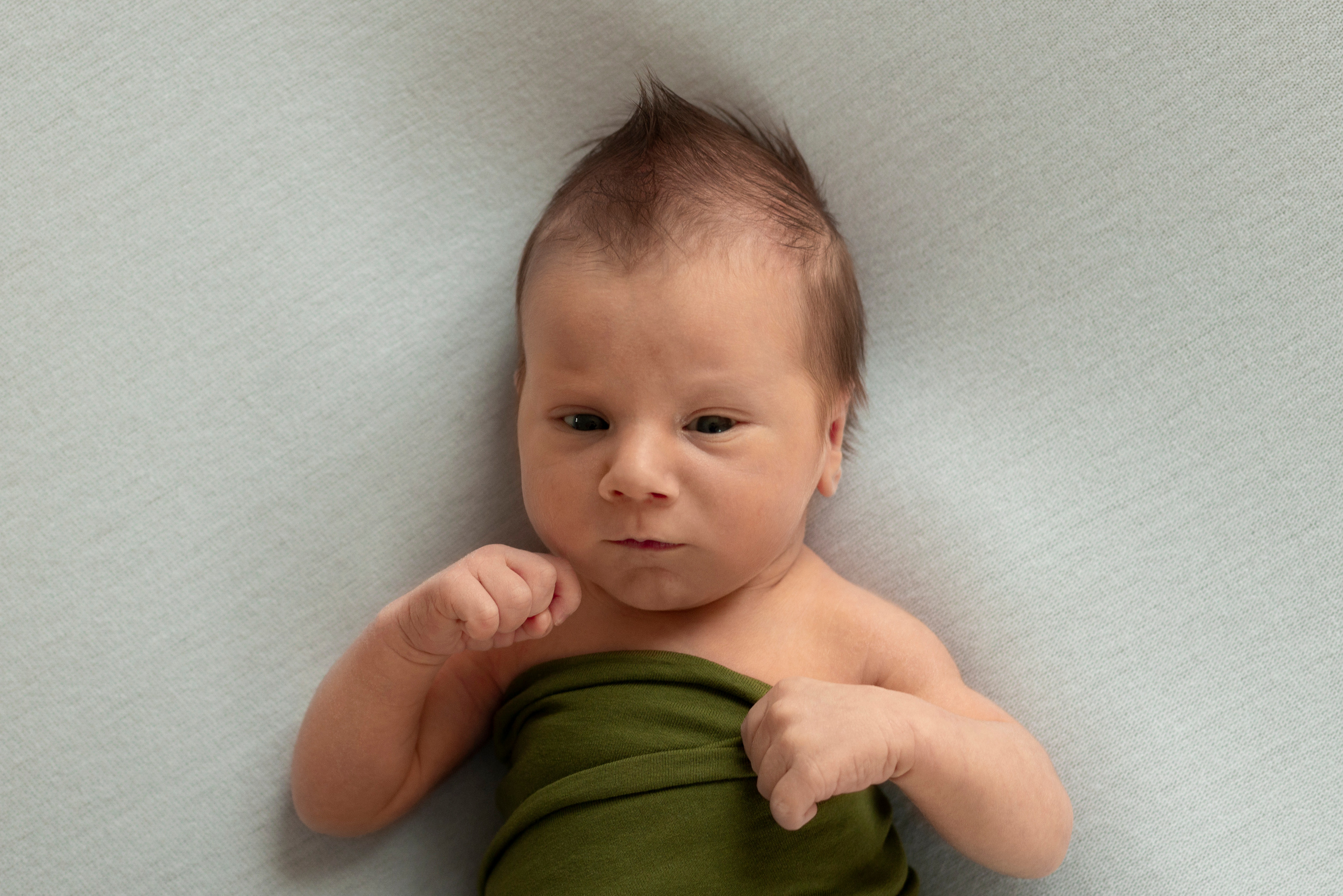 серьезный мальчик в позе боксера на светлом фоне