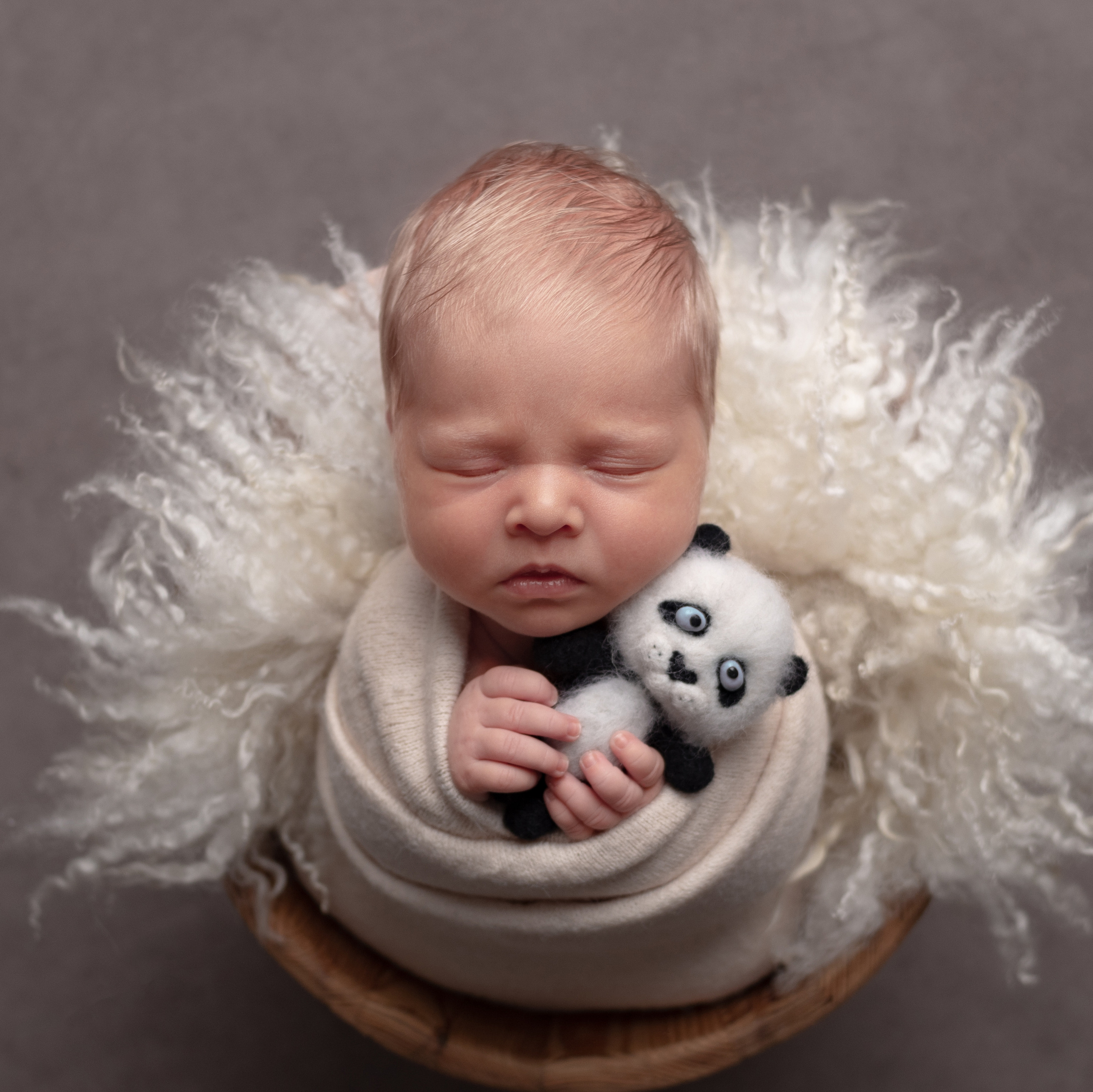 панда в руках у новорожденной малышки