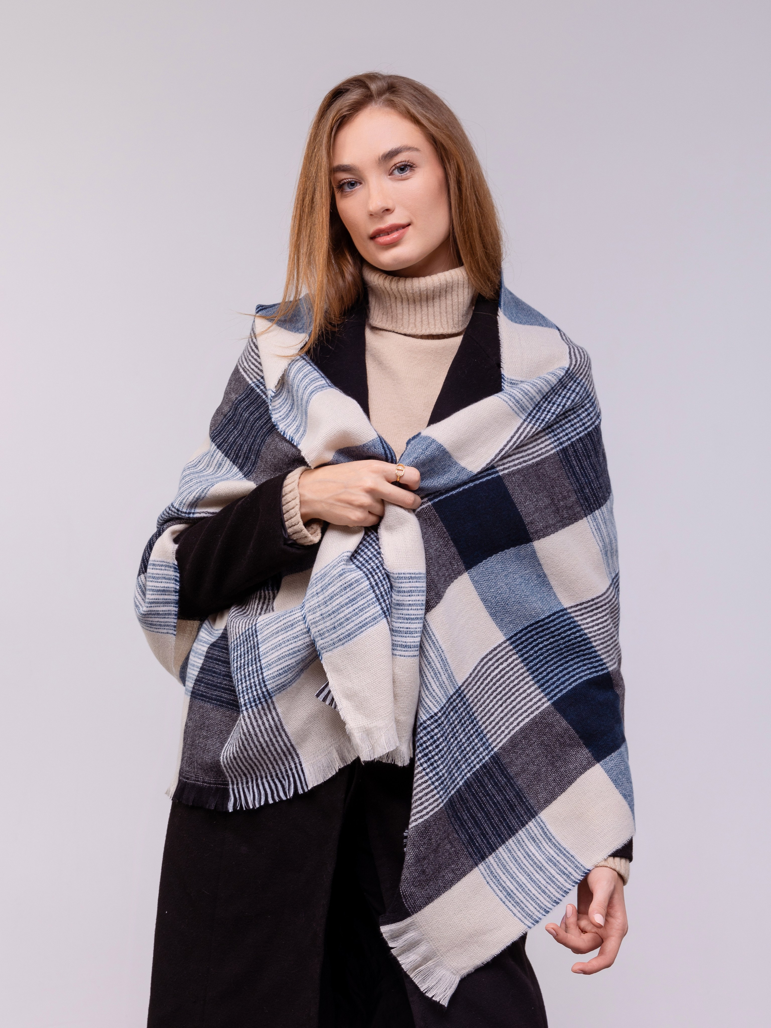 На плечах девушки палантин в крупную клетку.
