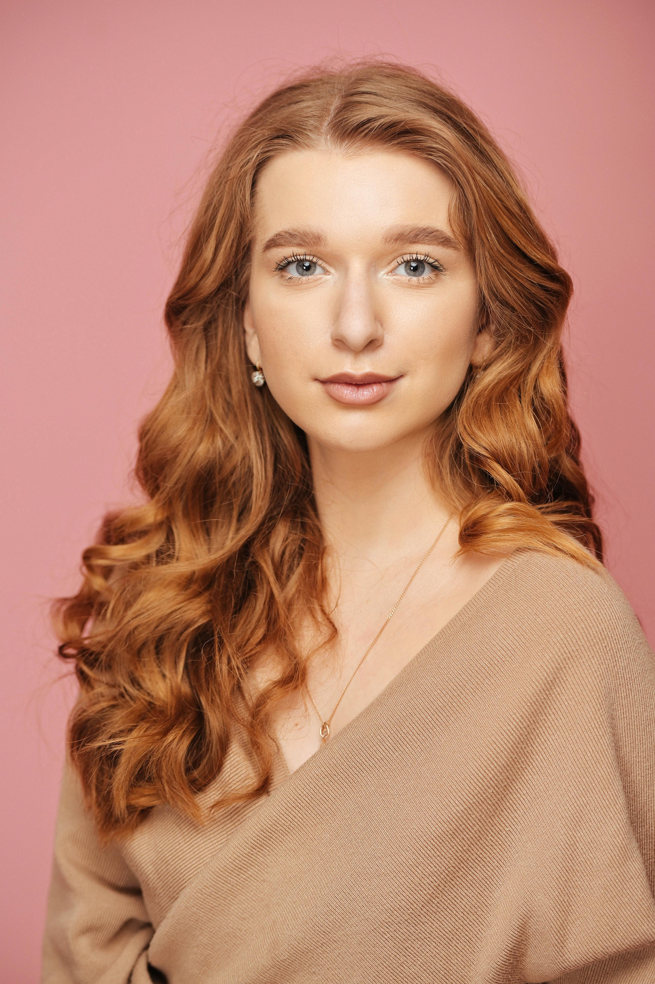 Женский портрет для выпускного альбома на розовом фоне в студиии