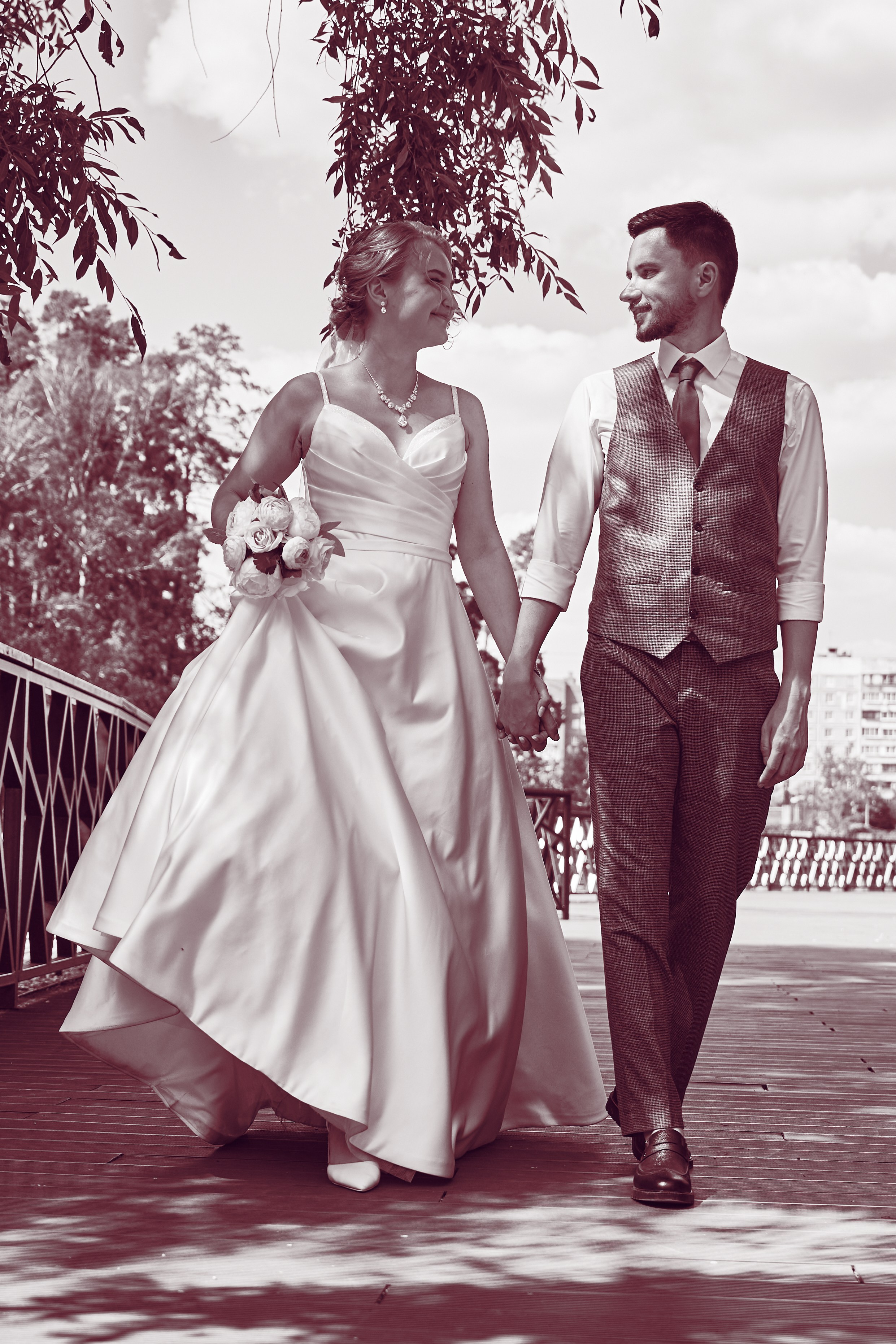 невеста и жених идут по набережной в парке