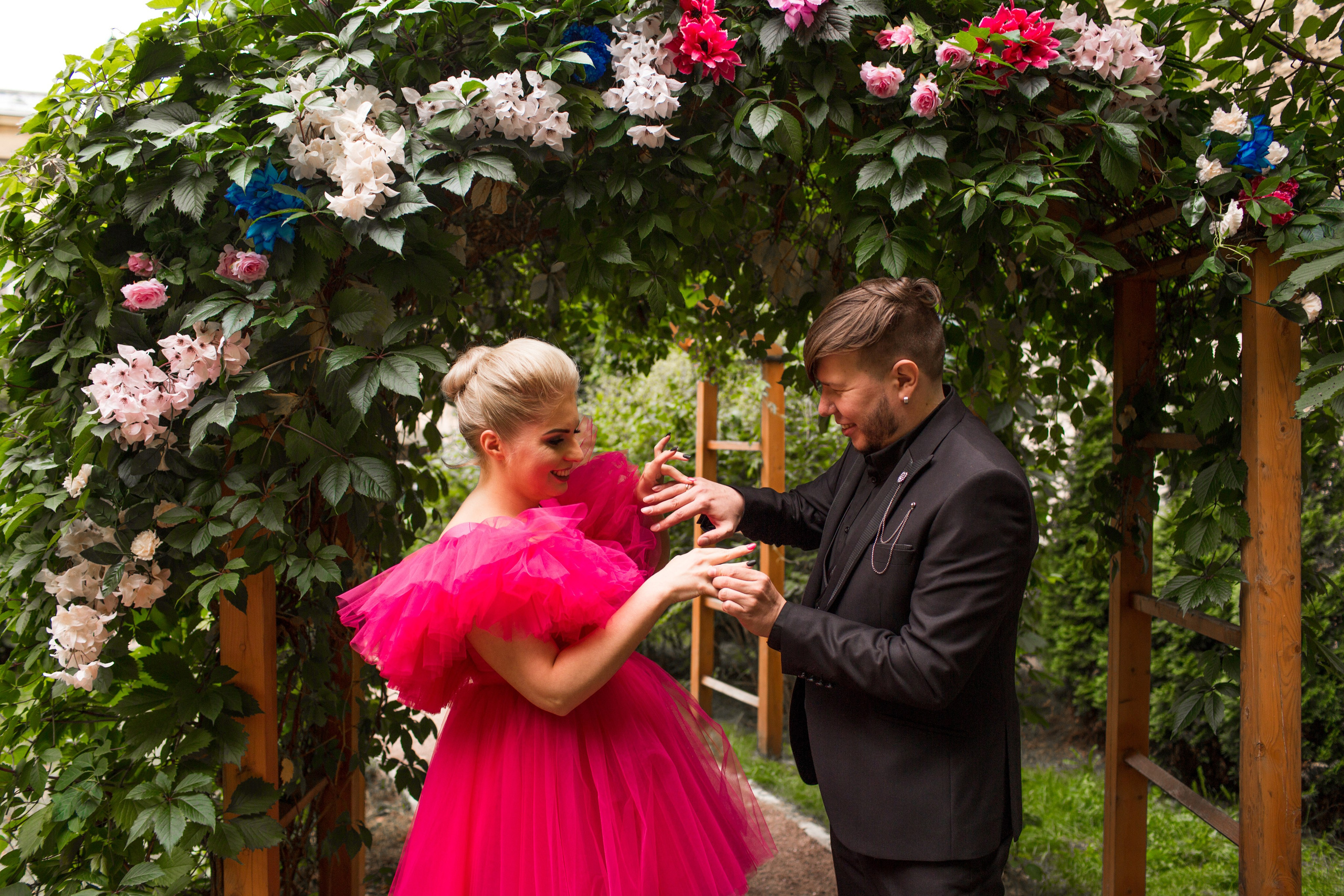 Невеста в красном платье позирует на фоне старинного здания Петербурга