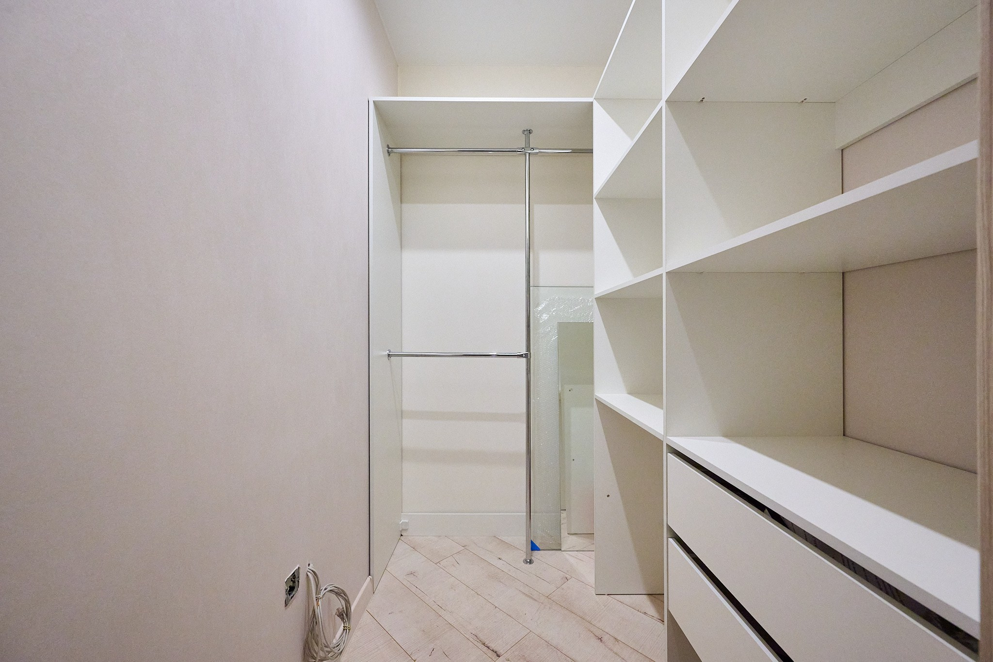 гардеробная с белыми шкафами и белой стеной 