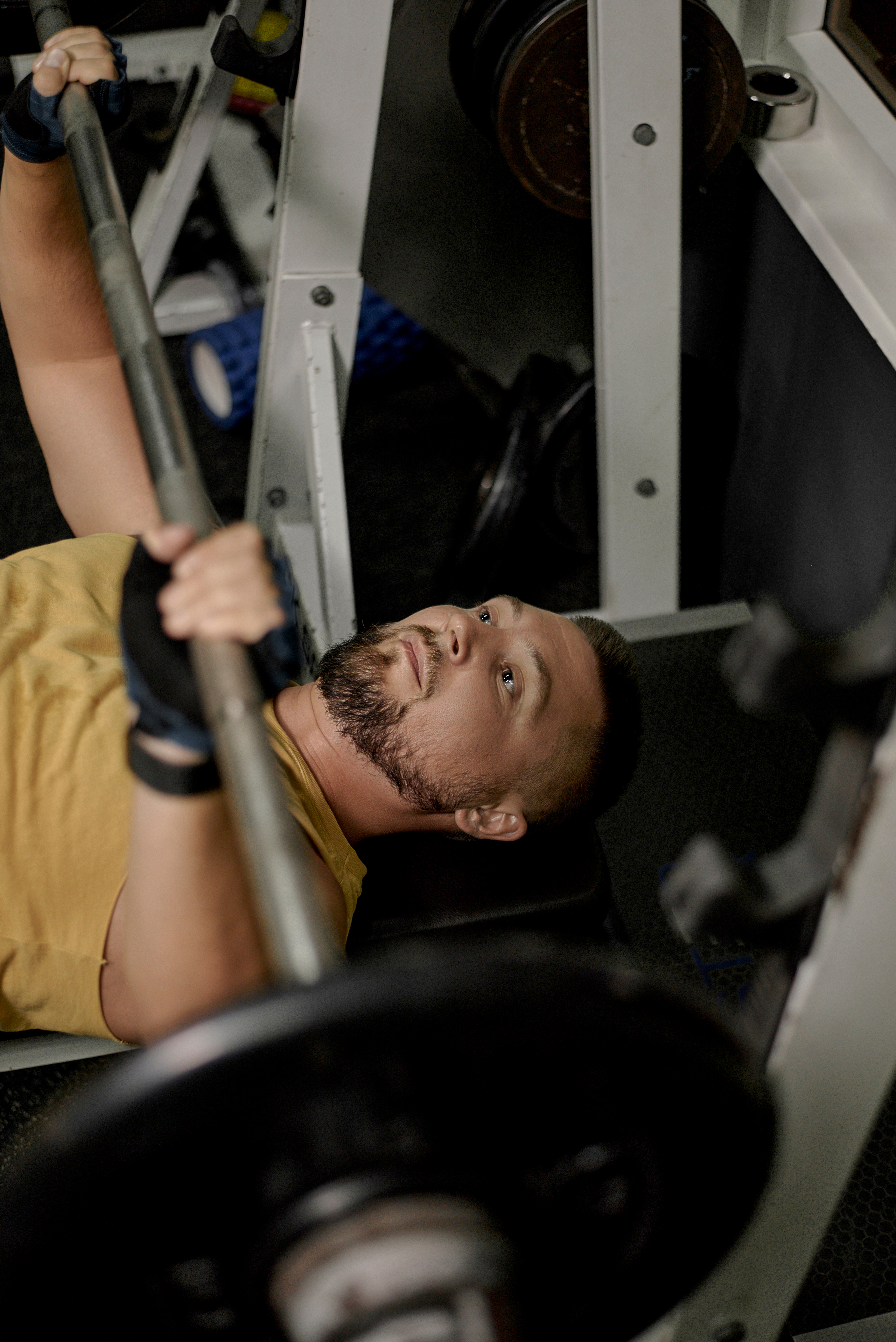 мужчина занимается в спортзале со штангой