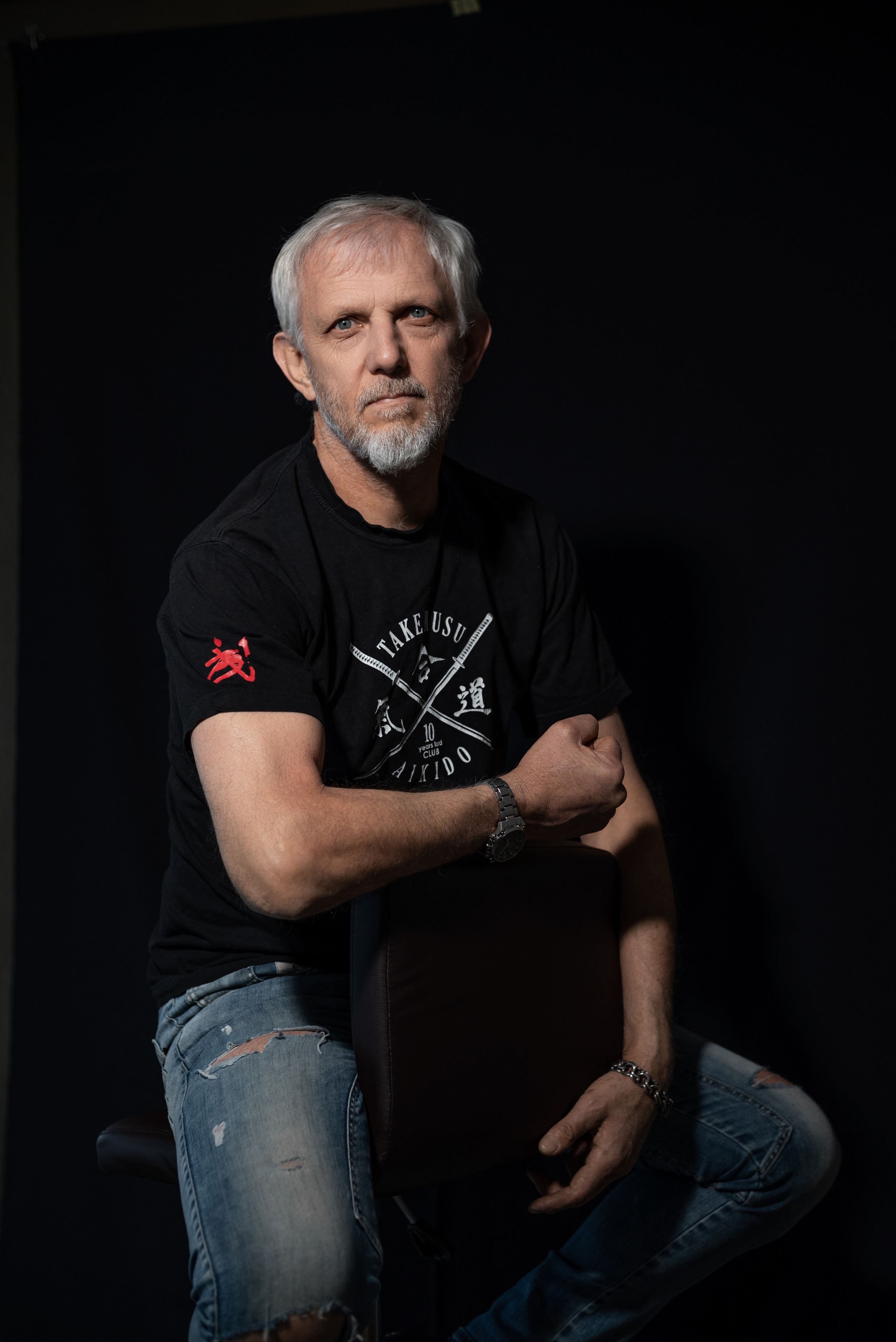 мужской портрет в низком ключе  в джинсах и футболке айкидо