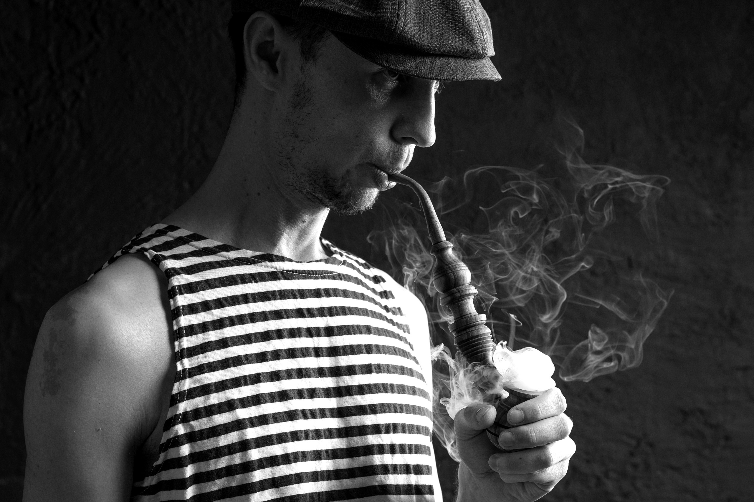 Мужской портрет . Моряк. Мужчина в кепке курит трубку. фото в низком ключе.