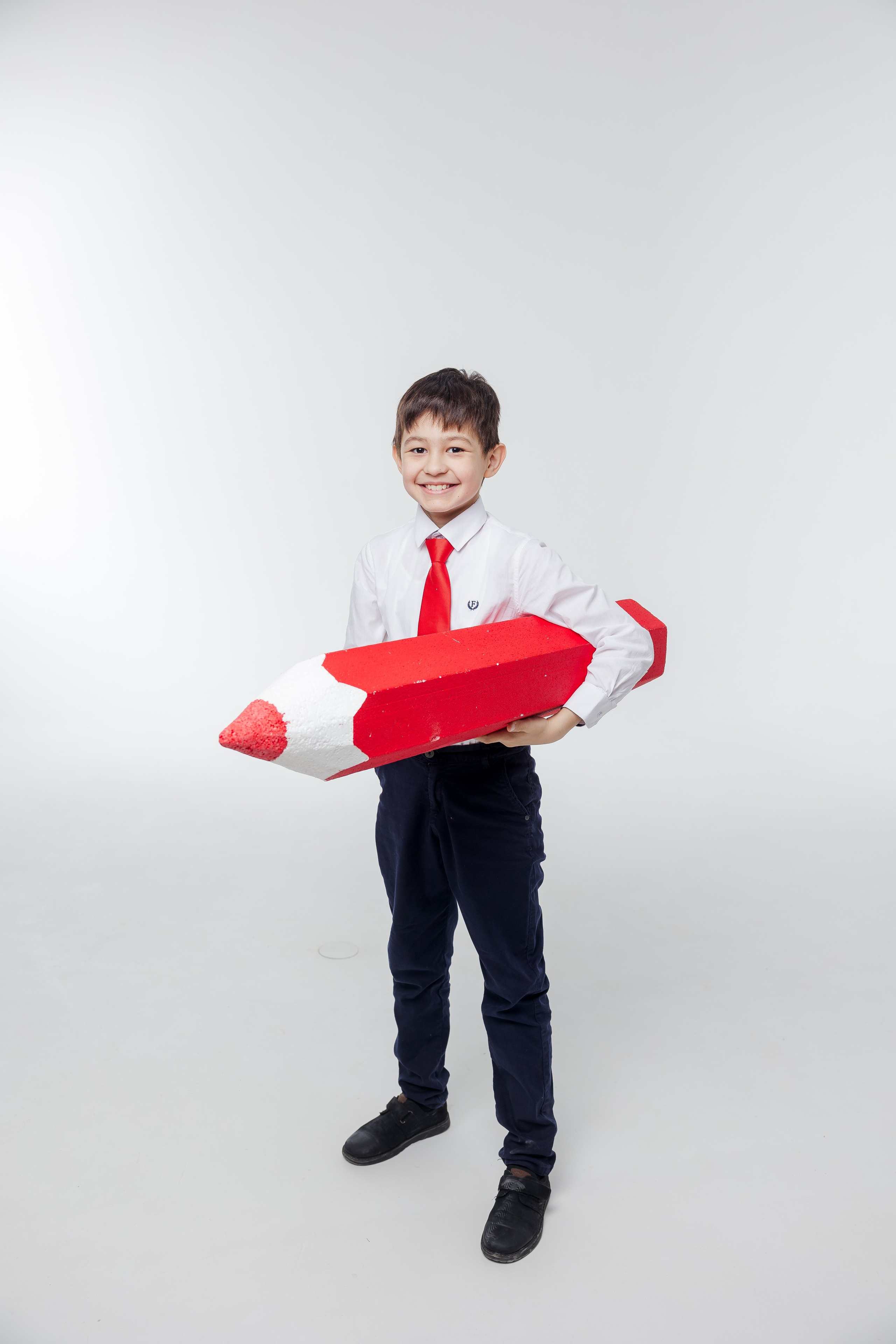 Портрет мальчика с красным карандашом в студии