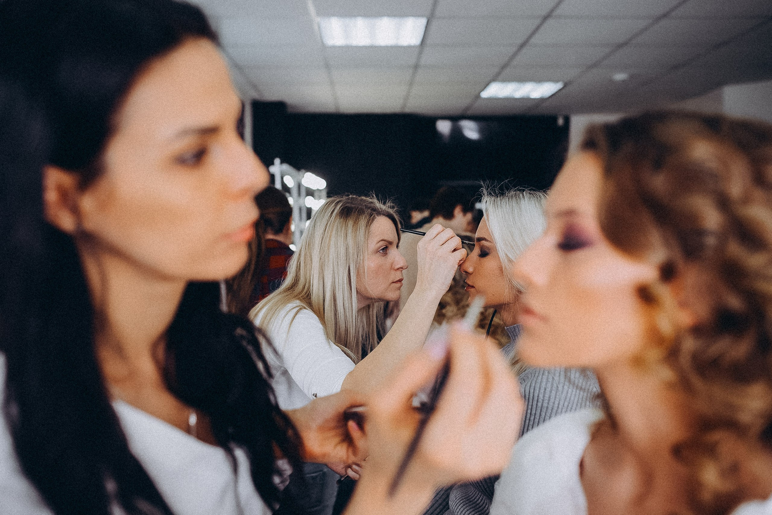 Командная работа мастеров: одновременное создание прически и макияжа для финалистки.