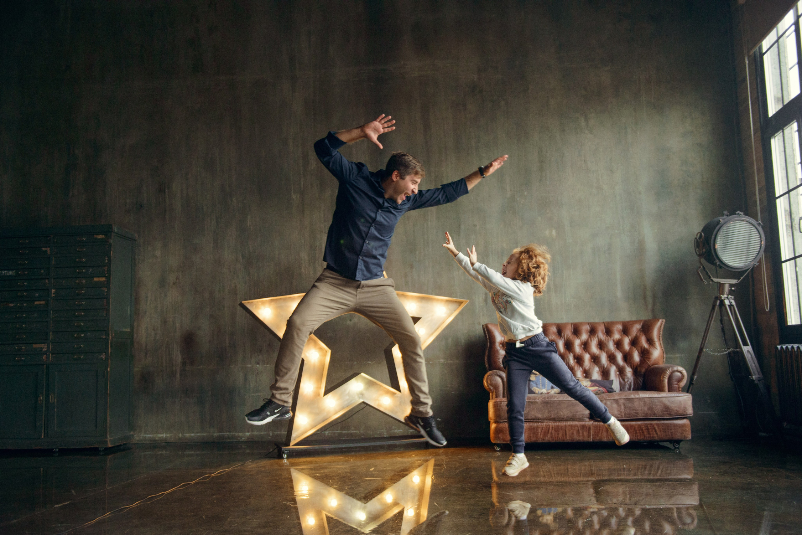 dad and daughter in a dark photo studio