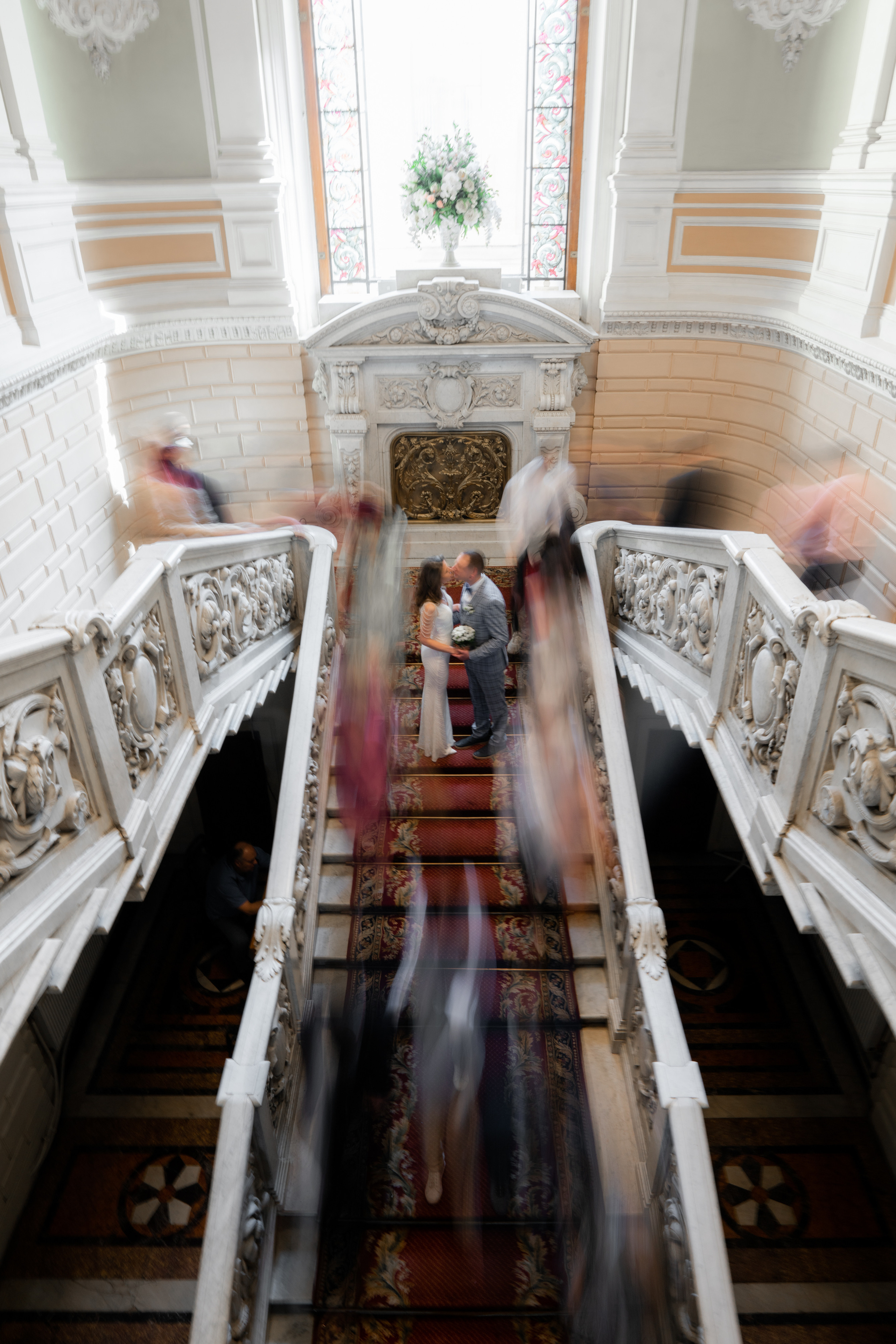 Жених и невеста стоят и целуются а вокруг размыты люди