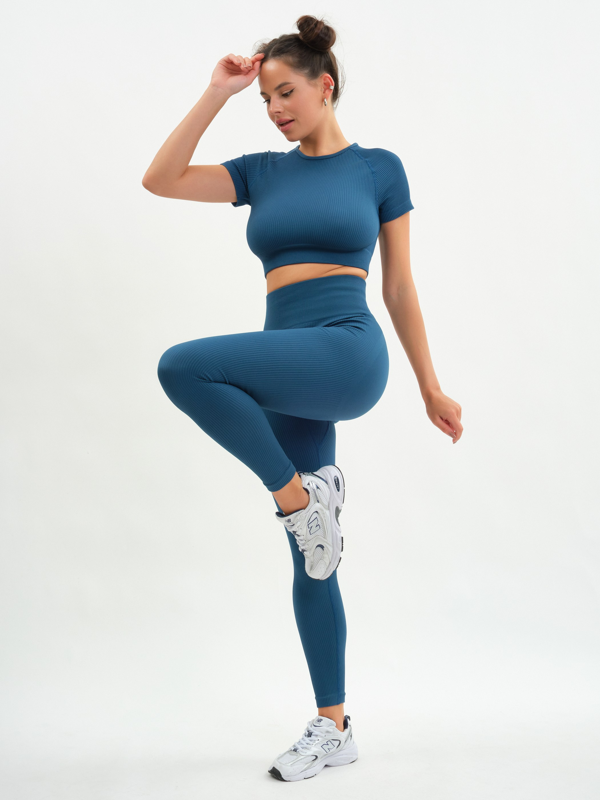 Женщина в спортивном костюме на белом фоне