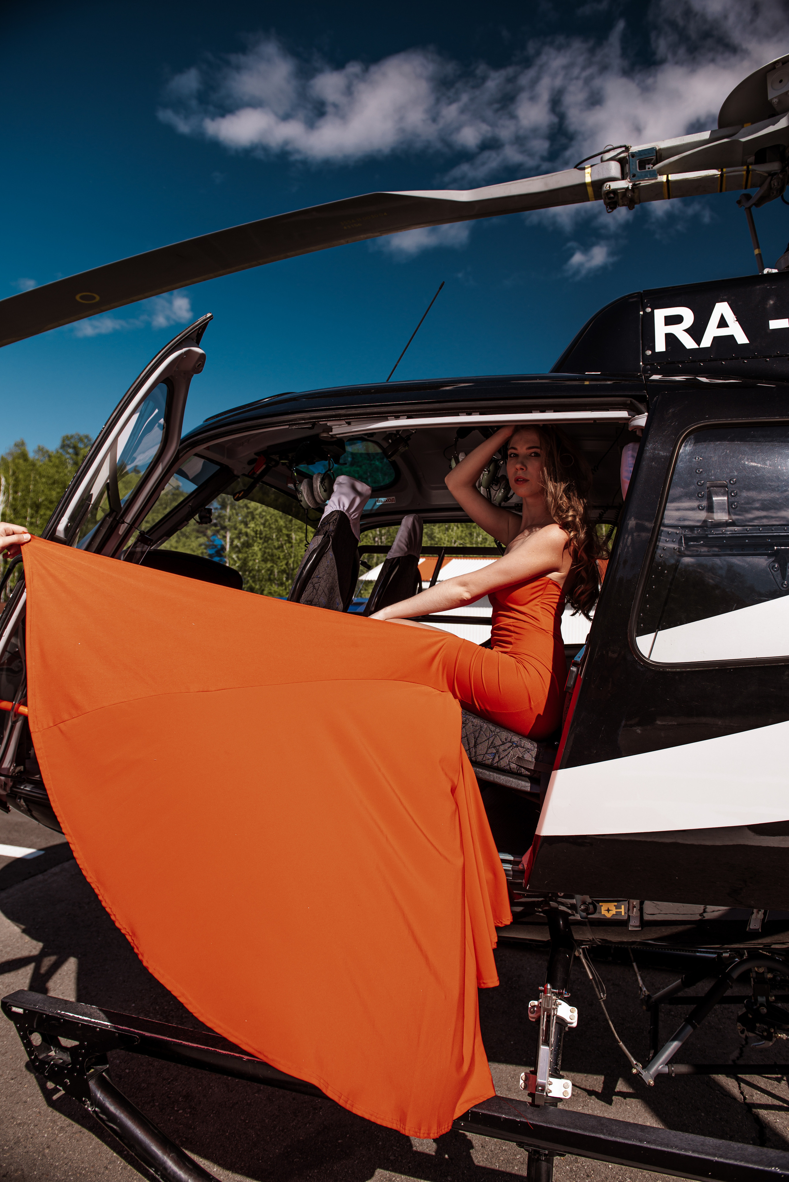 Девушка в красном платье на вертолете