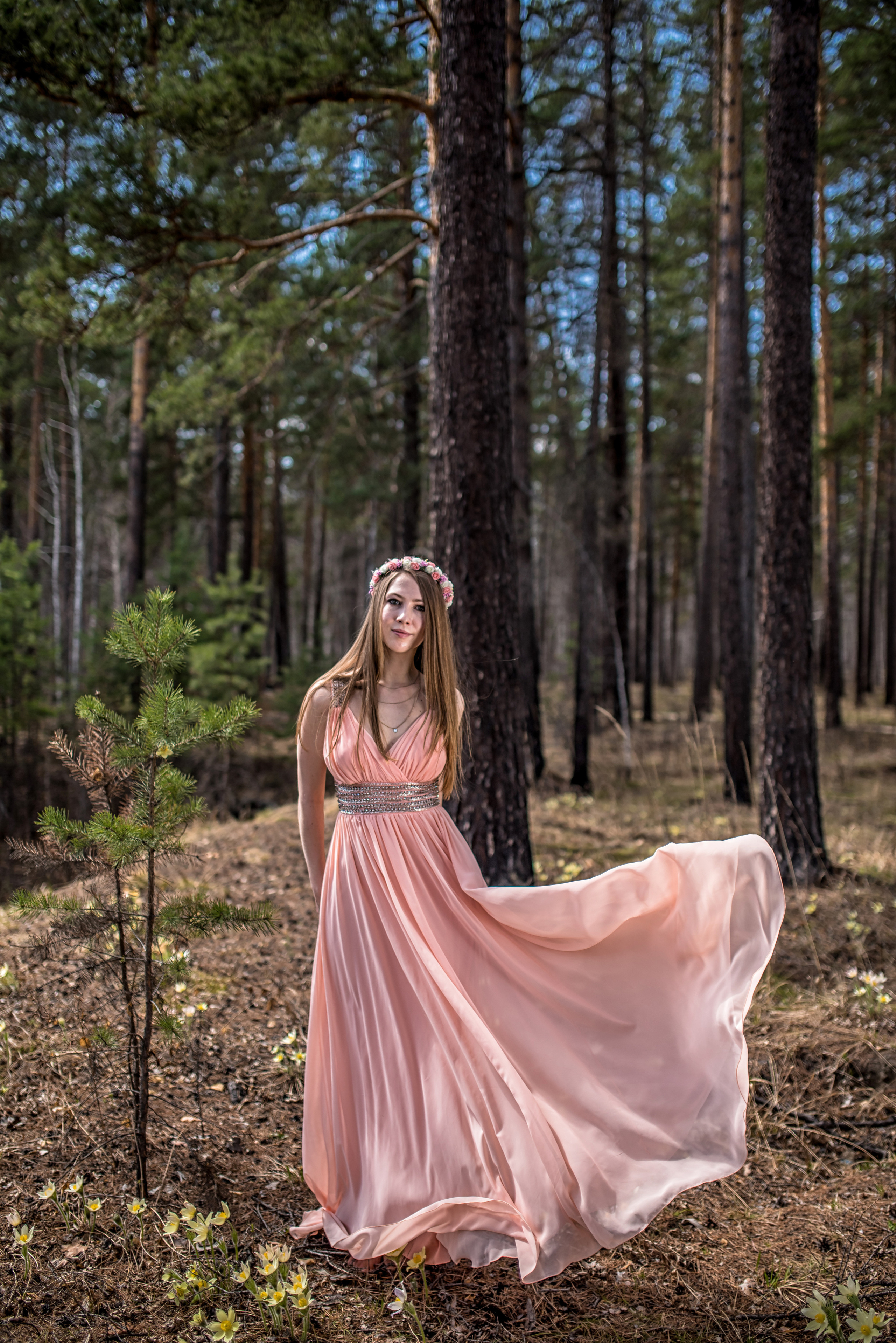 Девушка в шифоновом персиковом платье с летящим шлейфом в лесу