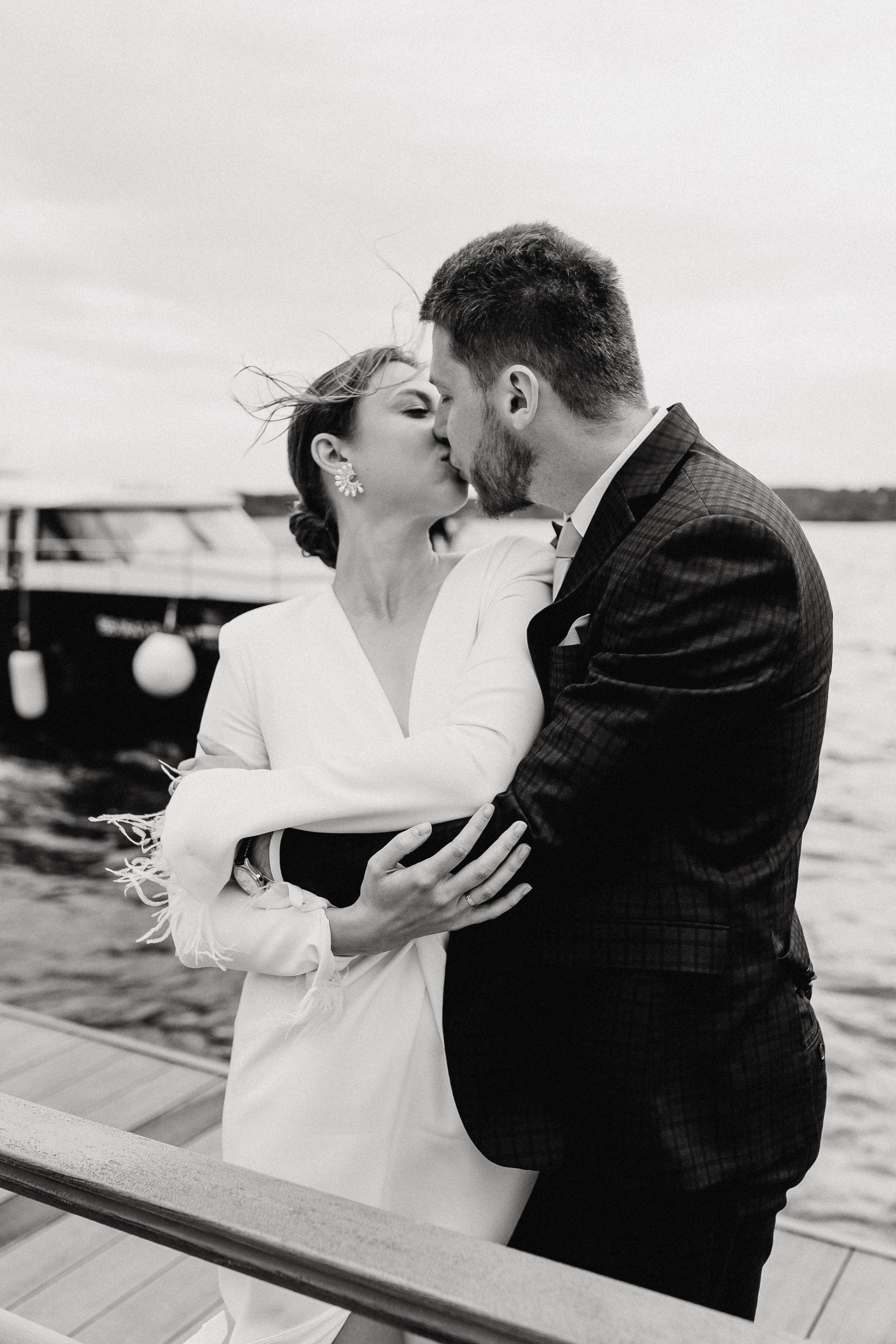 Жених и невеста целуются на фоне катера