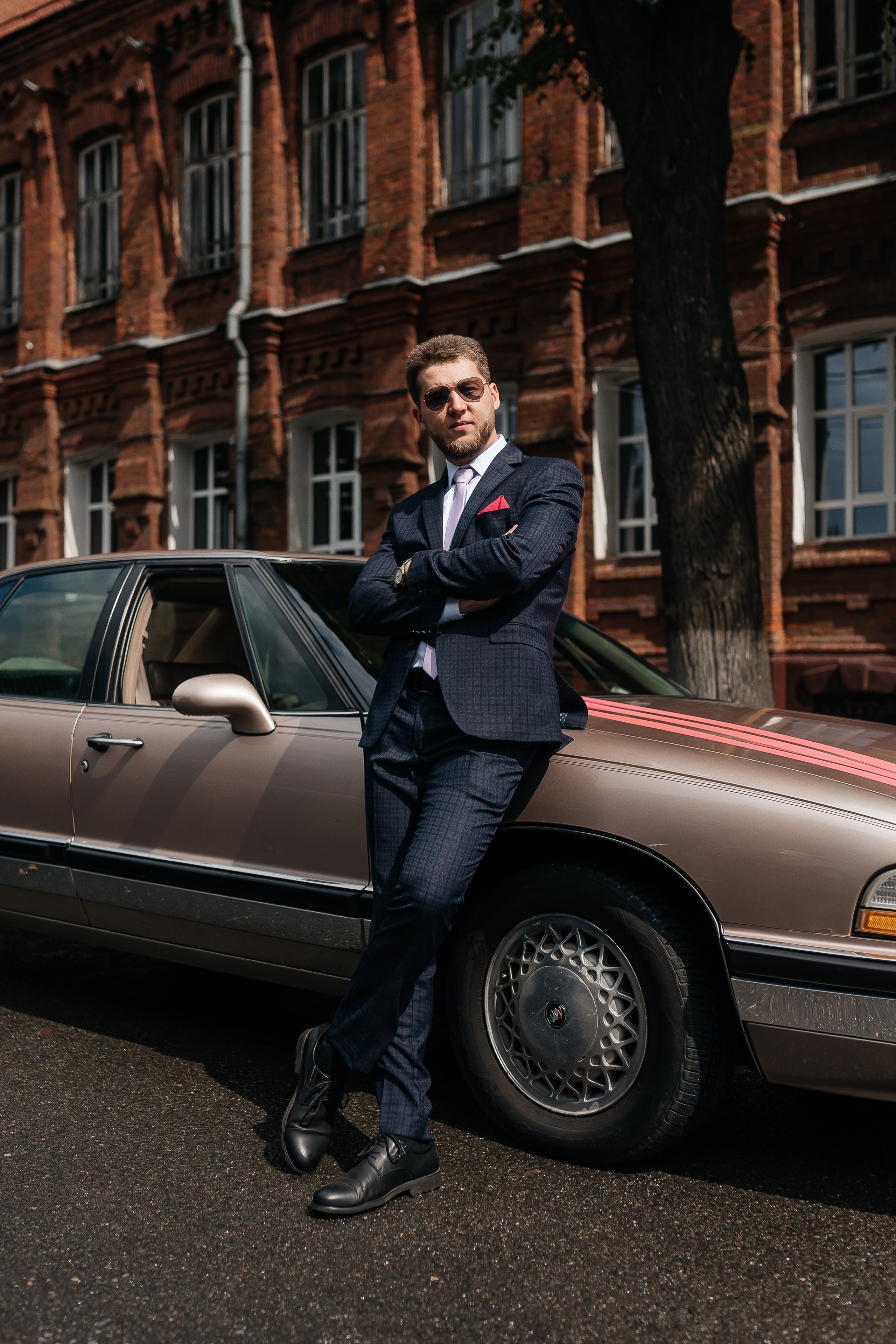 Фотография жениха на фоне свадебного автомобиля