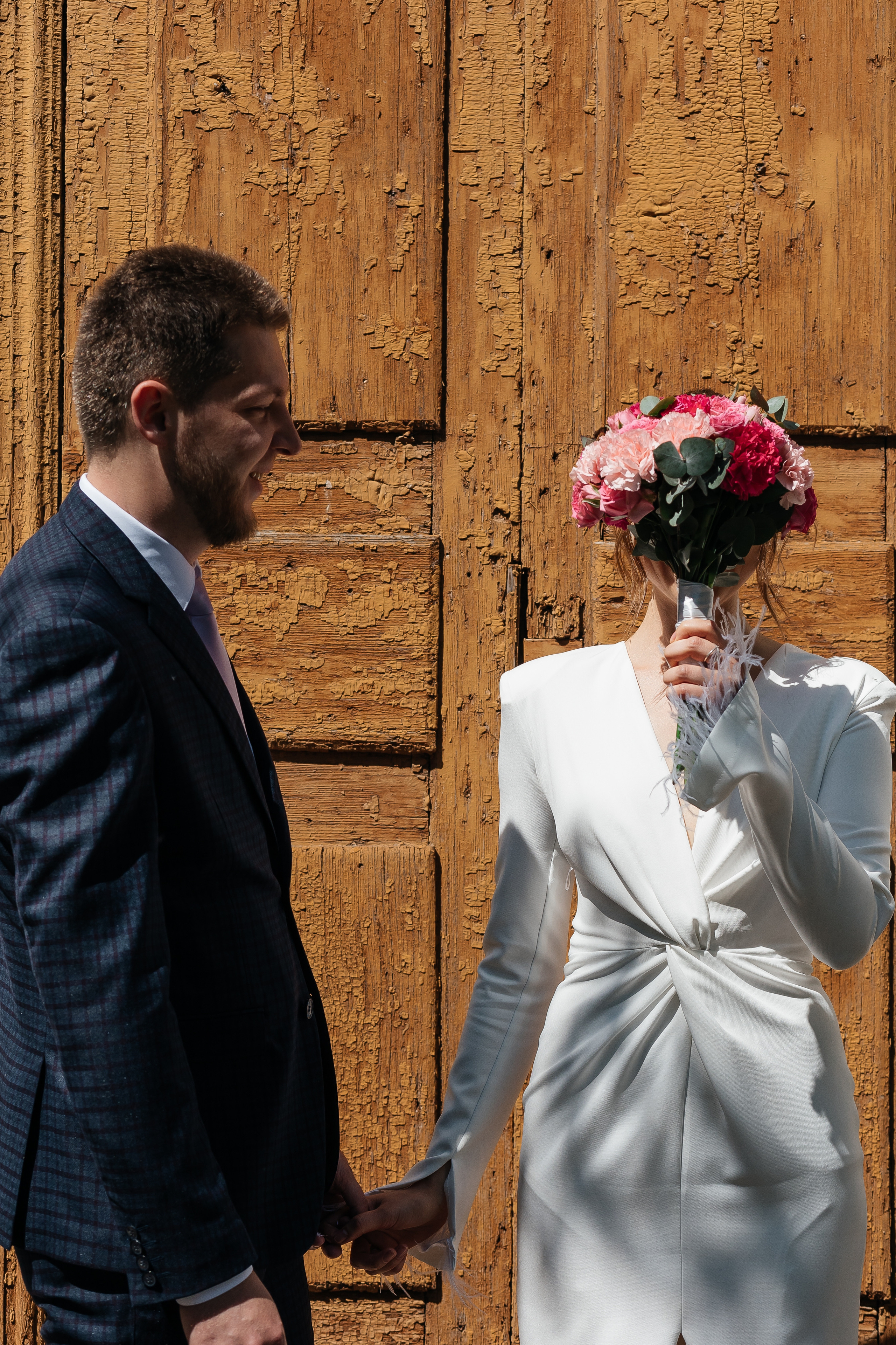 Невеста закрывает лицо букетом 