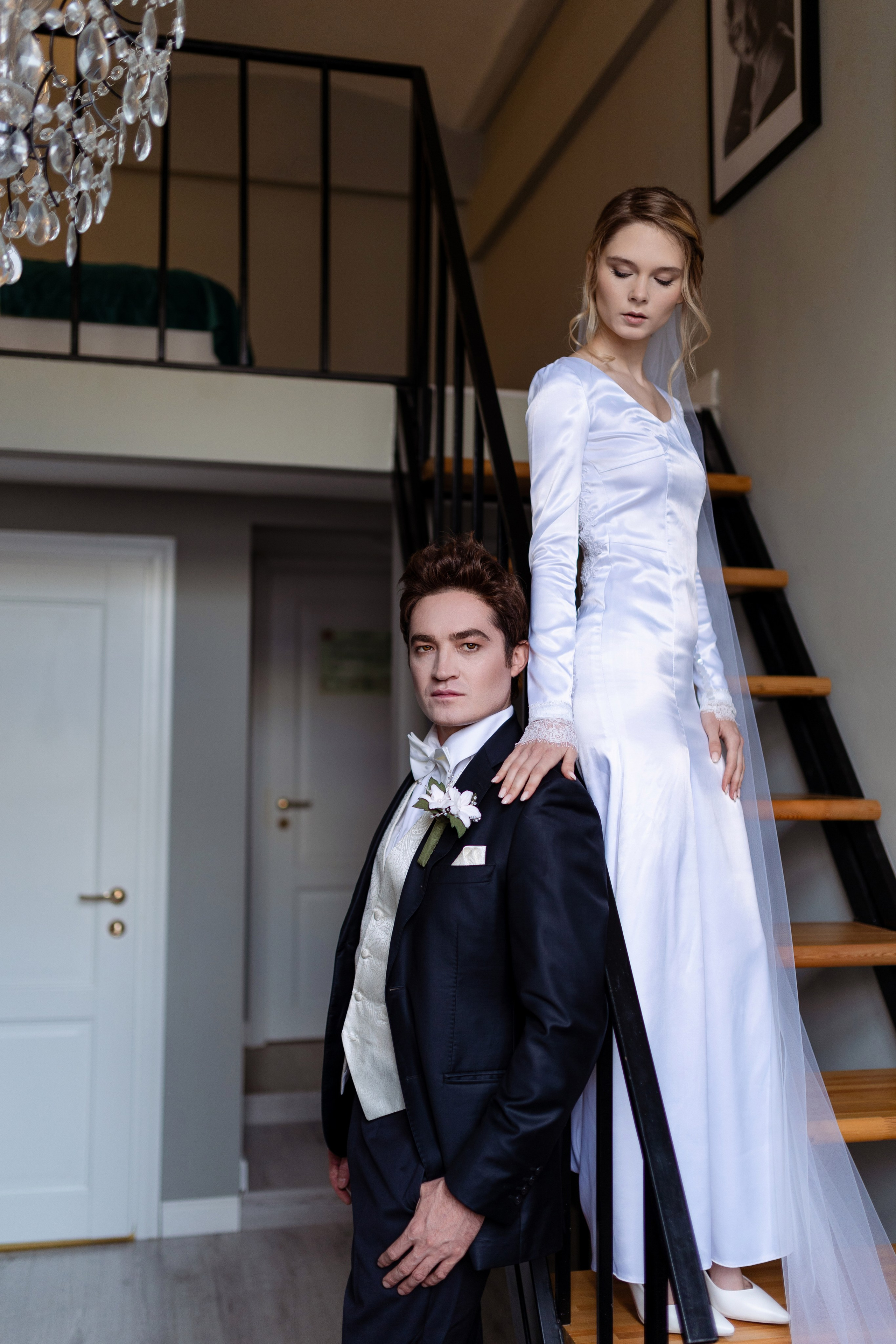 Невеста спустилась по лестнице еще ниже, положила руку на плечо жениху.