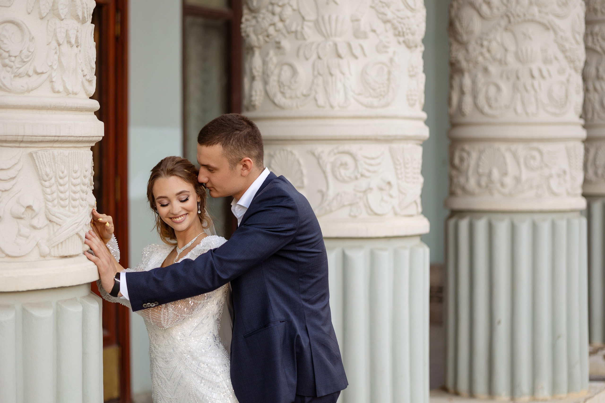 Молодые  у трех колонн.Молодой что то шепчет  молодой на ушко.