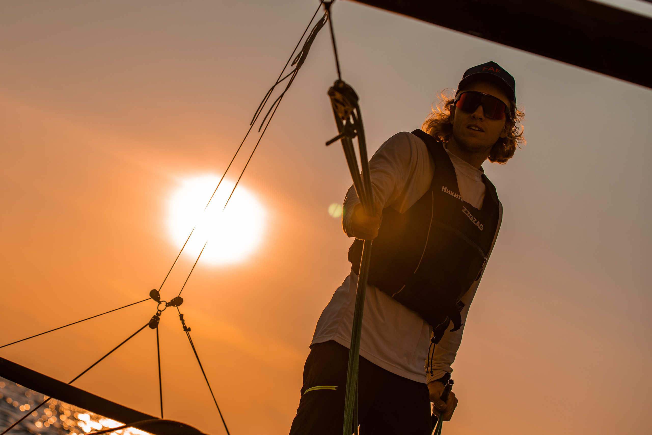 Яхтсмен на закате, шкипер парусной яхты крупным планом.