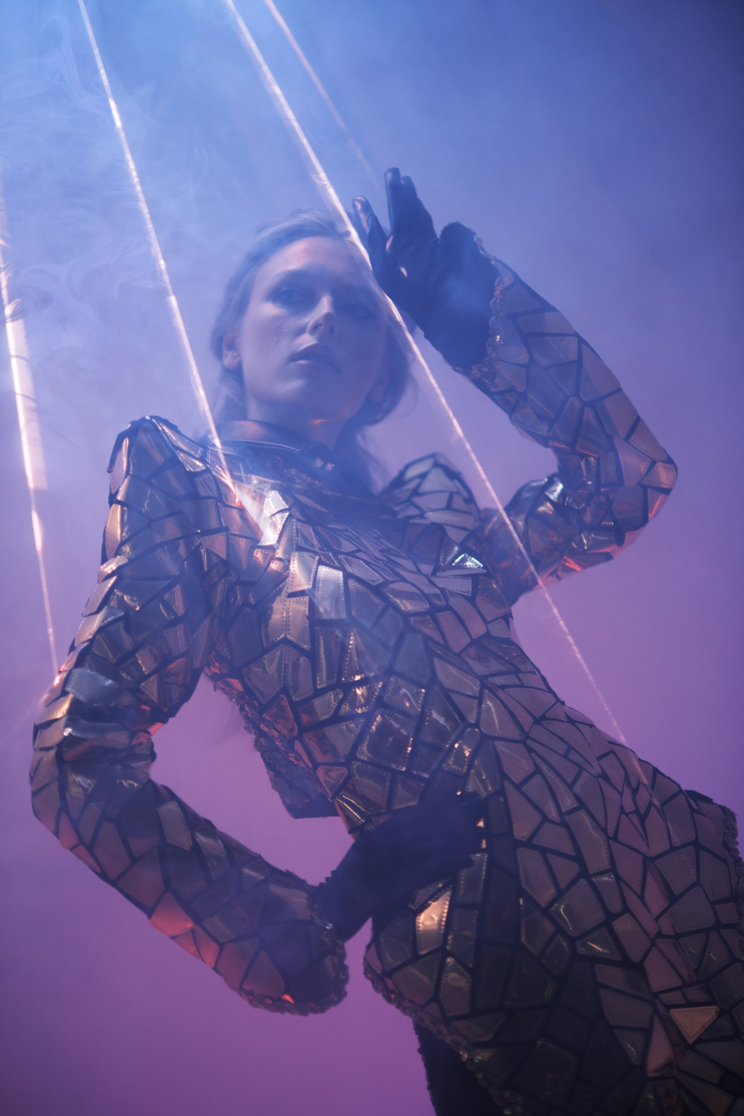 Фотосессия в стиле футуристической моды девушка в зеркальном костюме с отражения лазера