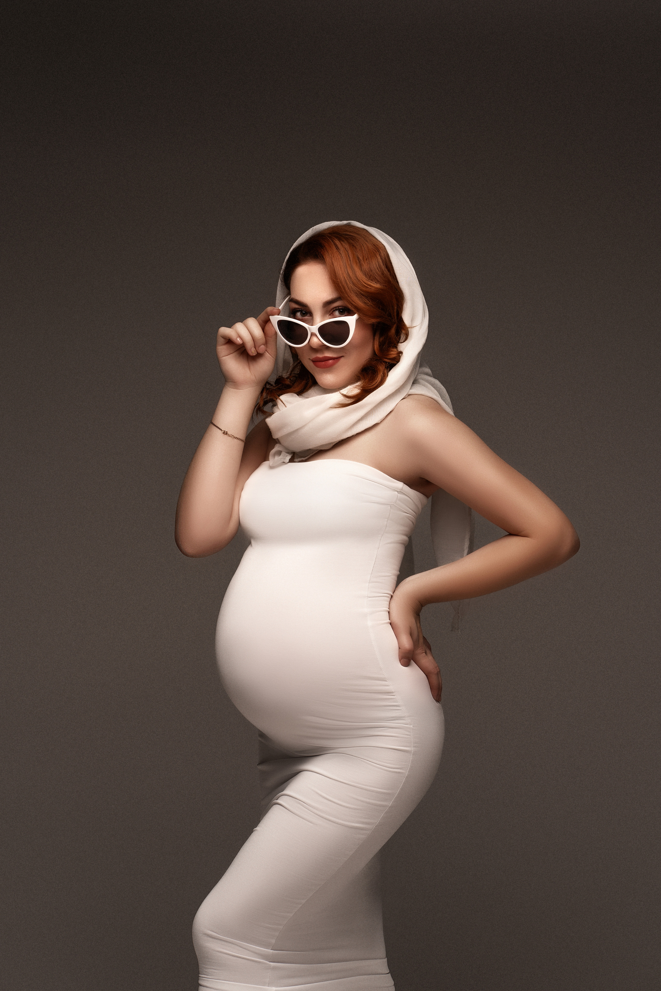 беременная девушка в белом платье с очками в студии в Минске