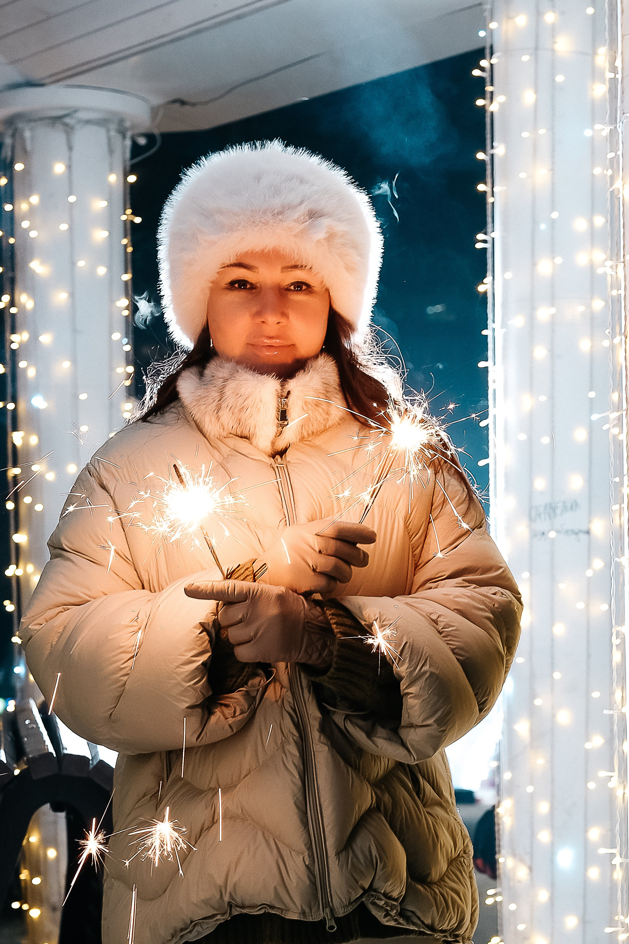 Новогодняя фотосессия в Чите: женщина держит бенгальские огни возле украшенных колонн