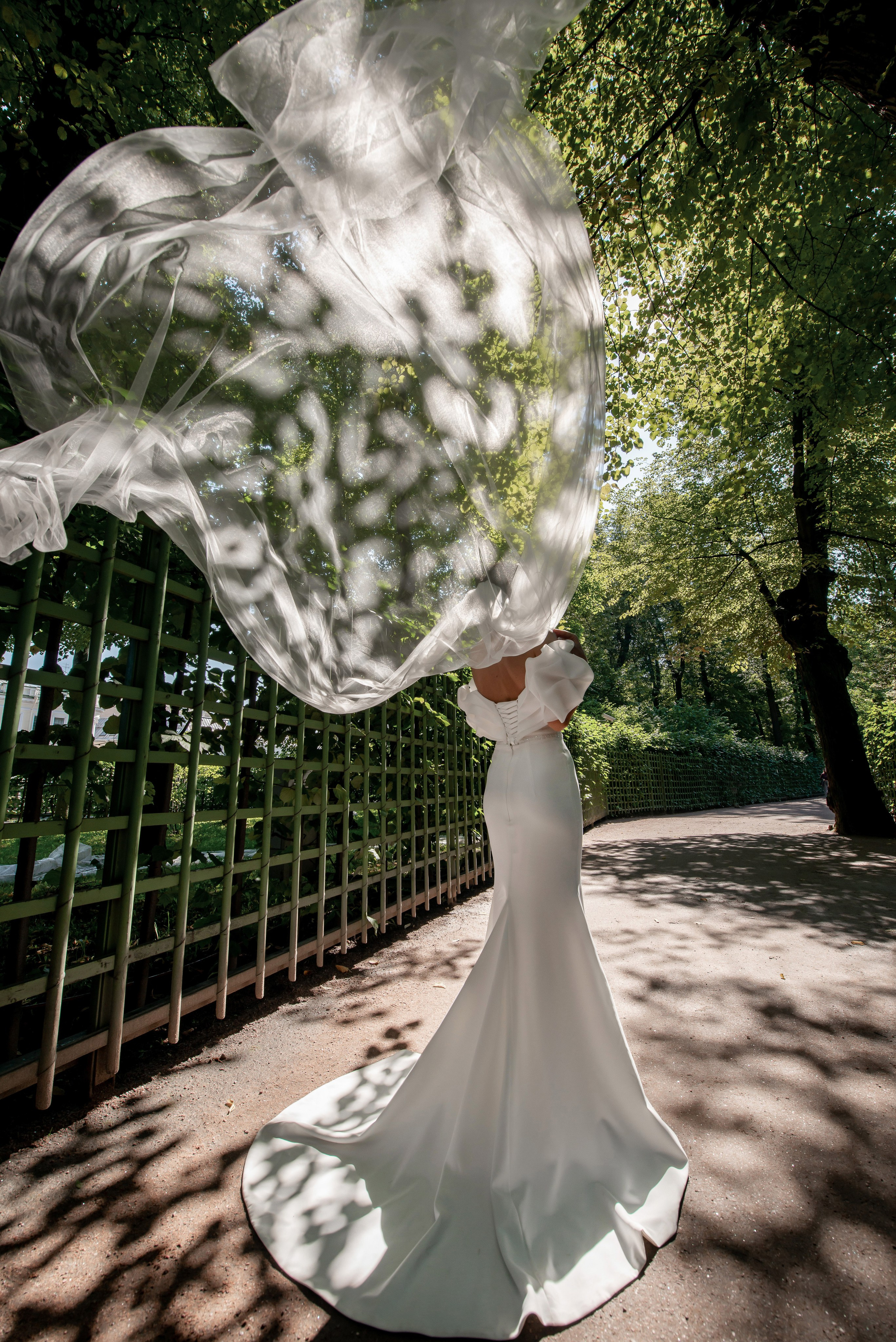 Летящая и развивающаяся фата невесты в Летнем саду