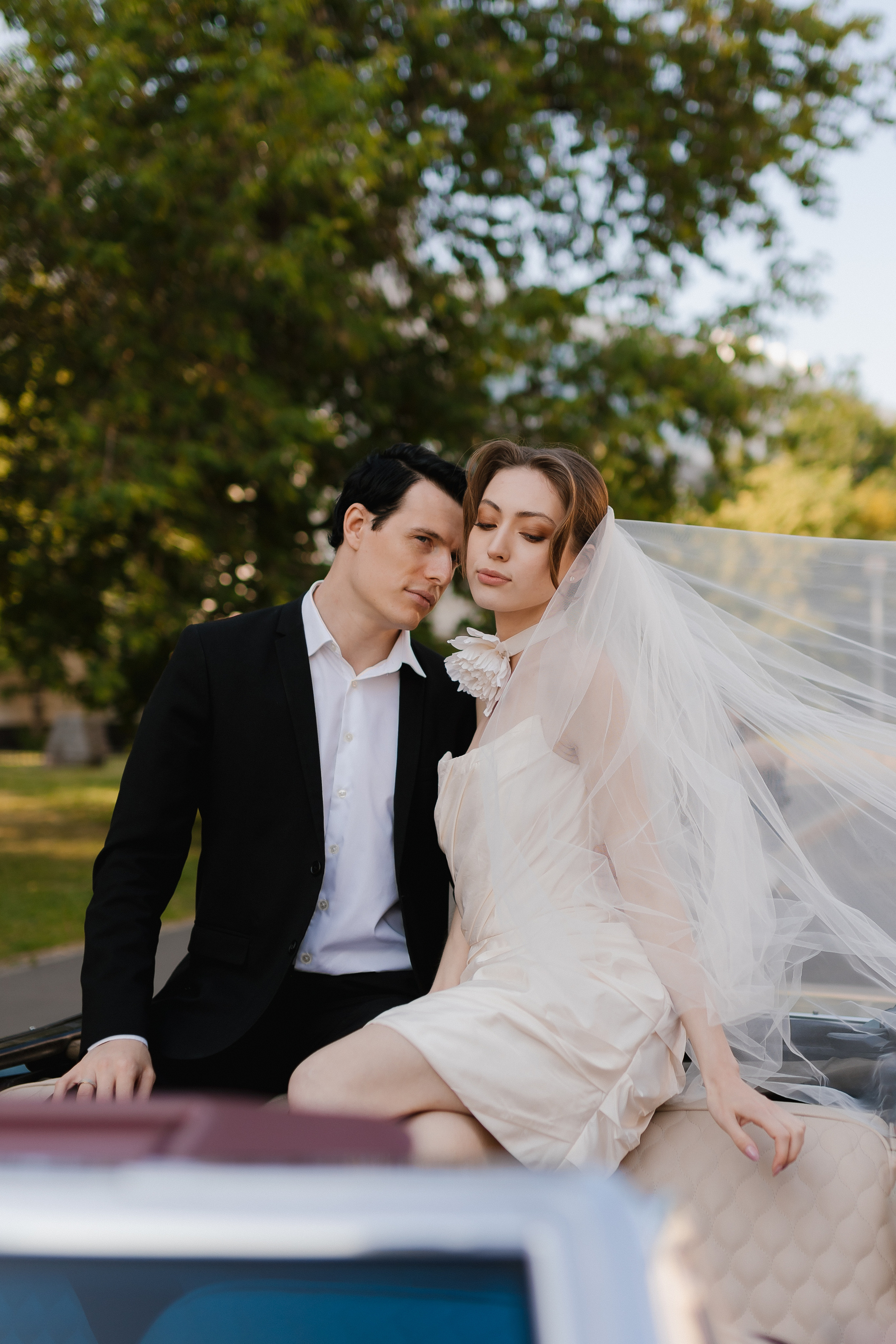 Нестандартный поворот сюжета: жених и невеста устроились комфортно на капоте кабриолета.