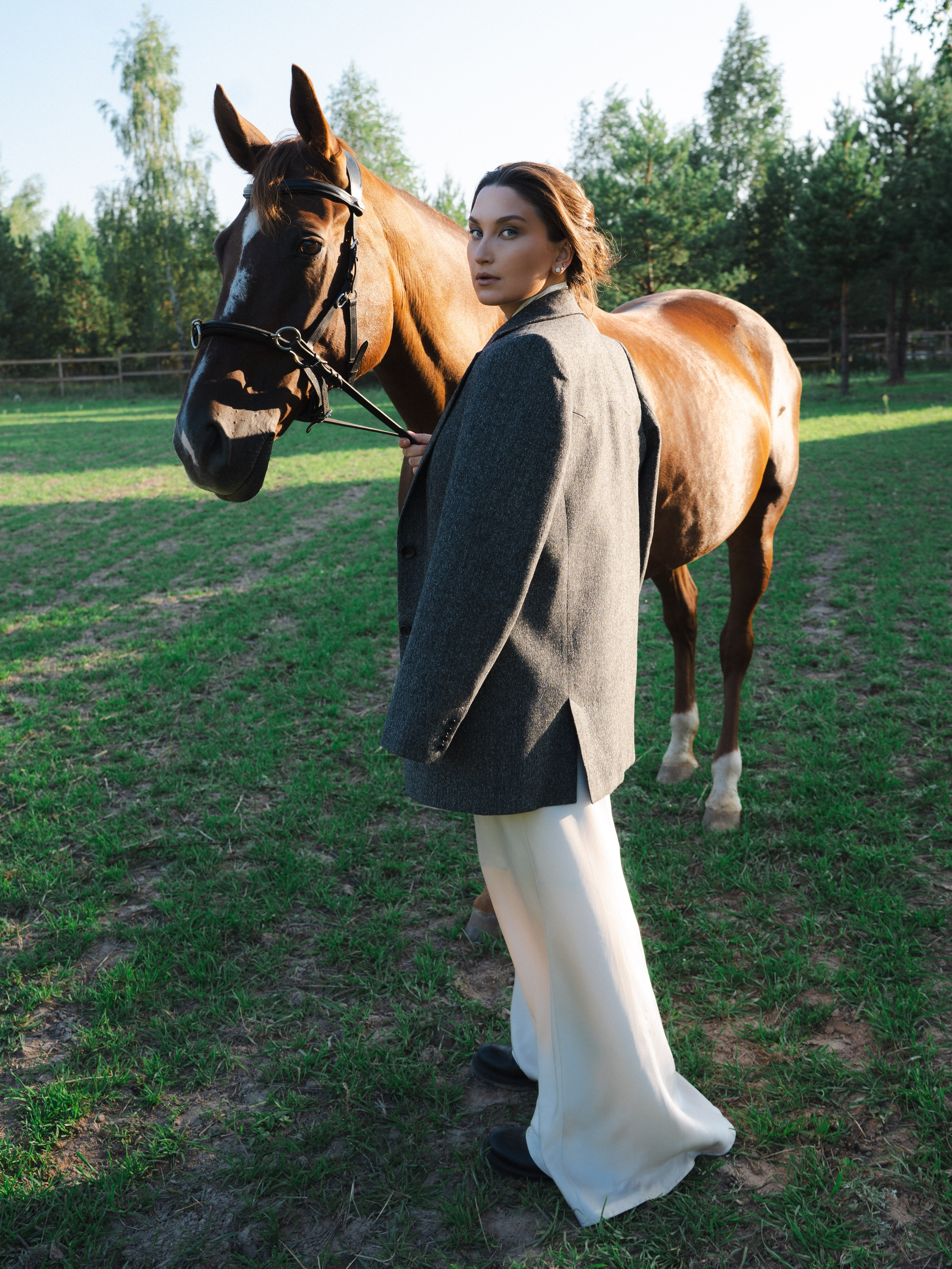 Девушка в красивом образе с лошадьми на конюшне