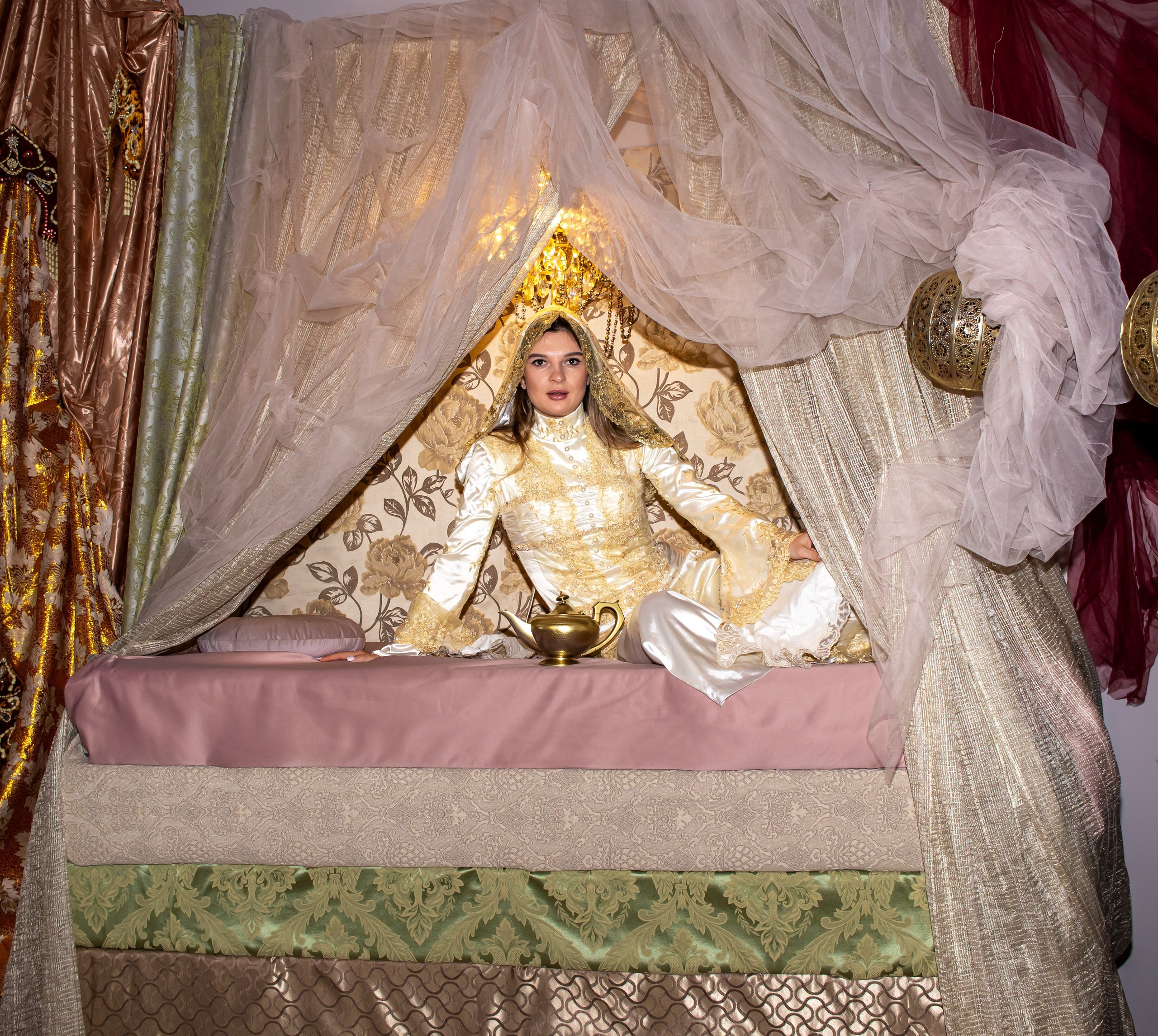Девушка в золотом платье лежит в восточном шатре — творческая фотосессия, фотограф Карасёва Елена