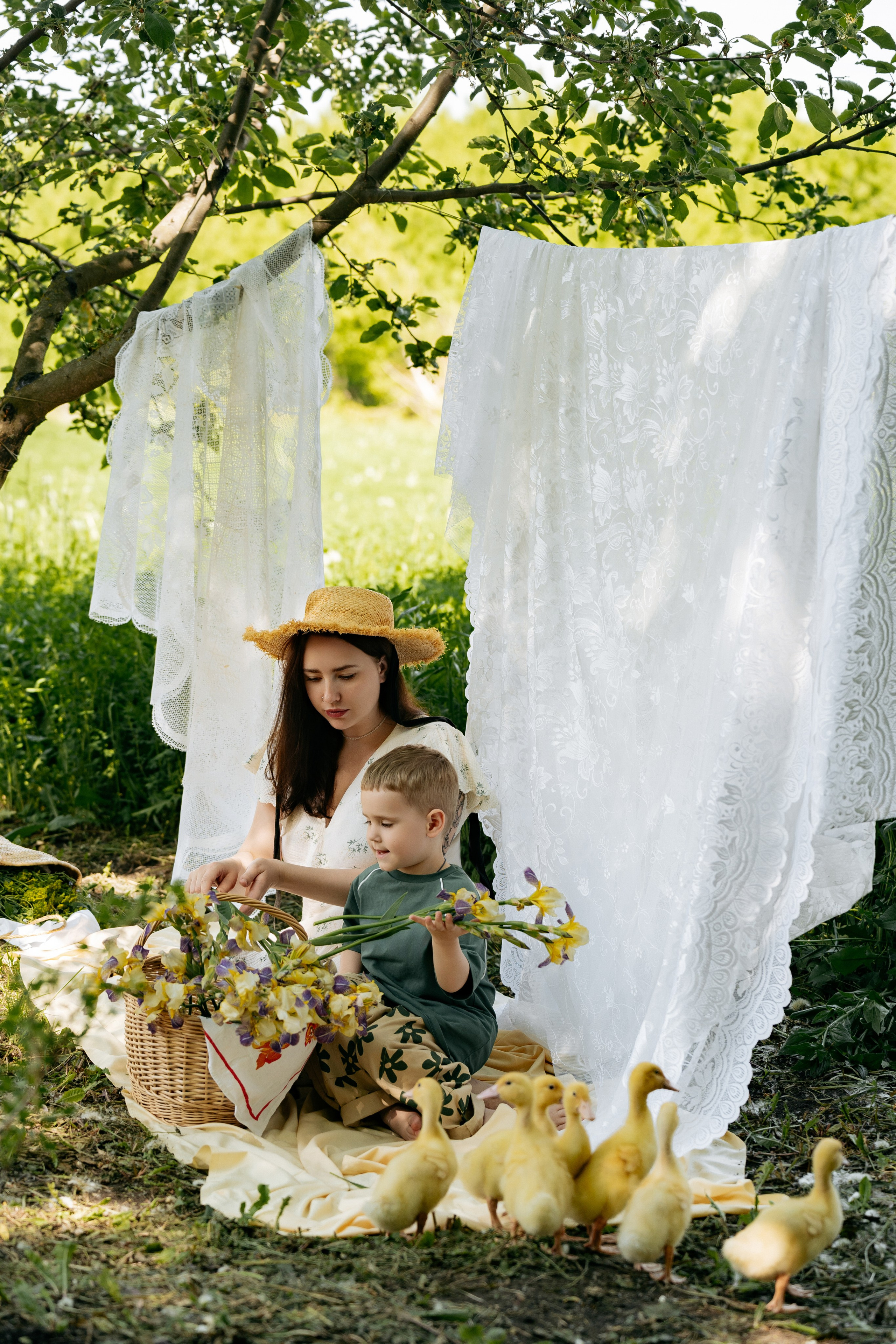  Мама и сын в пастельных тонах сидят на траве, утята в корзинке дополняют кадр, фотограф Голубицкая