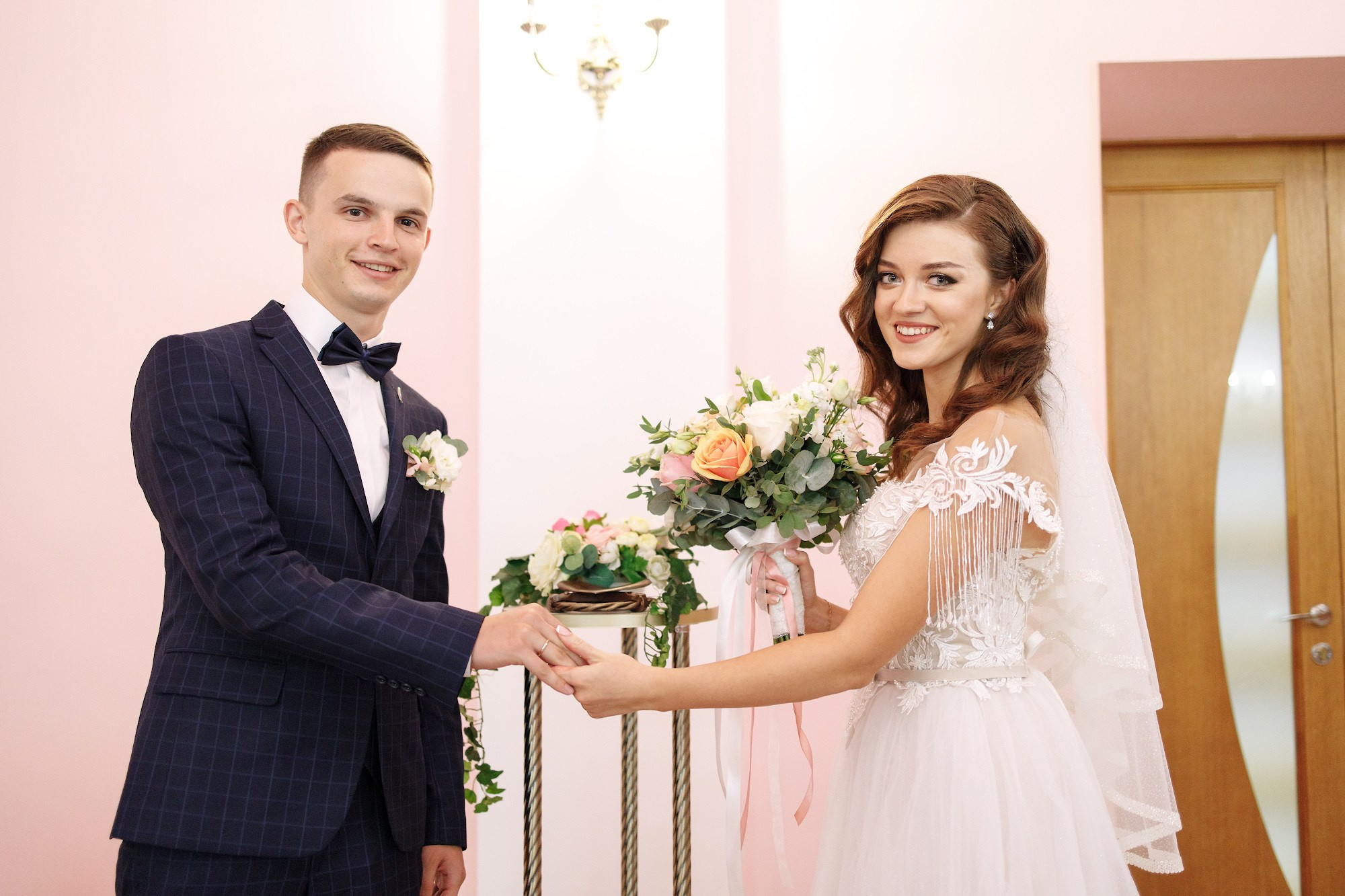 Жених с невестой обмениваются кольцами в загсе