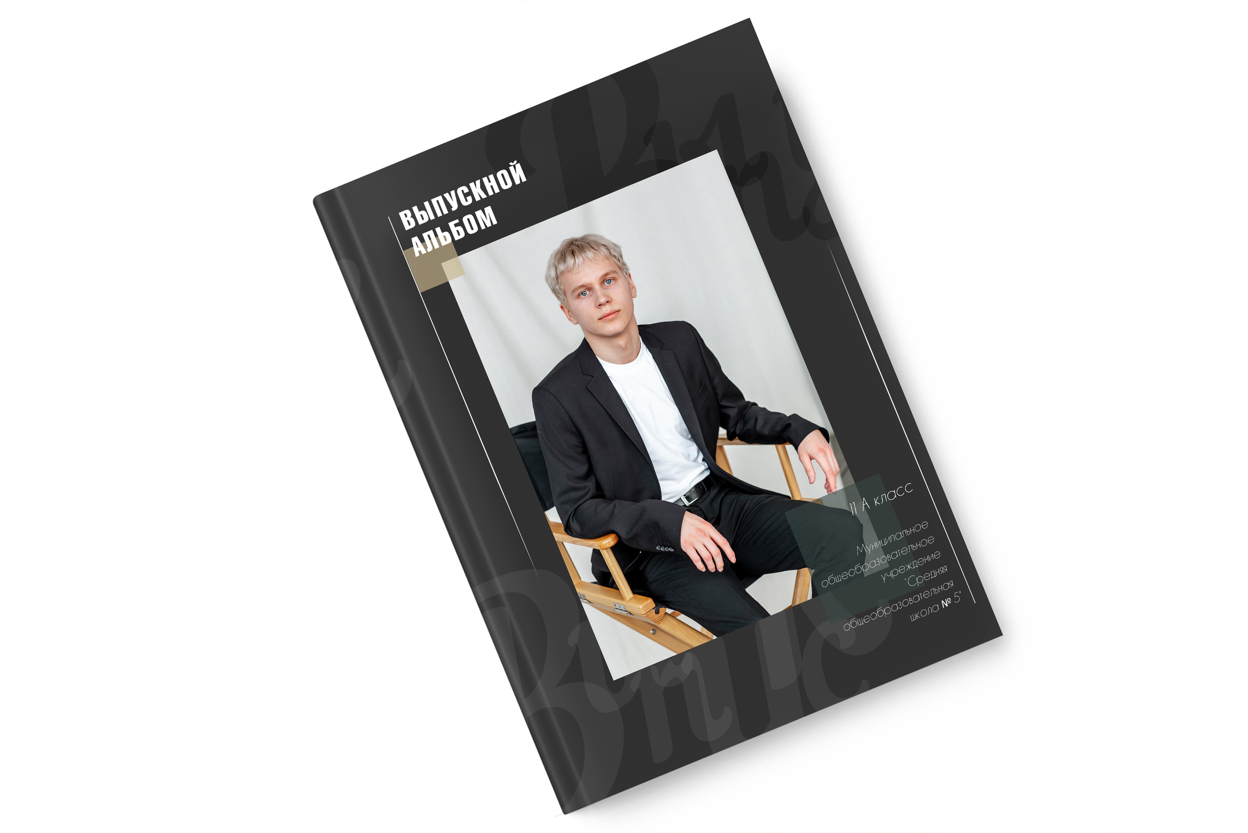 Красивый молодой блондин сидит на деревянном стуле режессера в жерном костюме и белой футболке