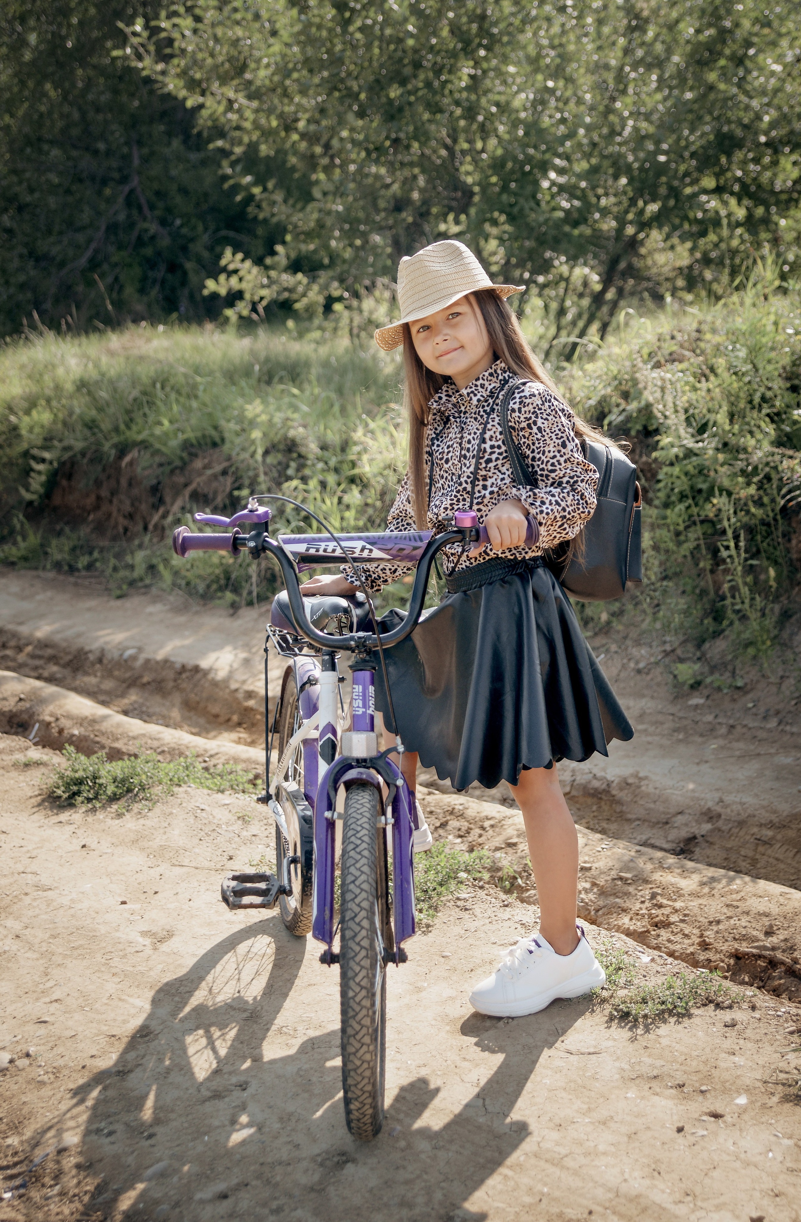 Детская фотосессия летом - девочка стоит с велосипедом