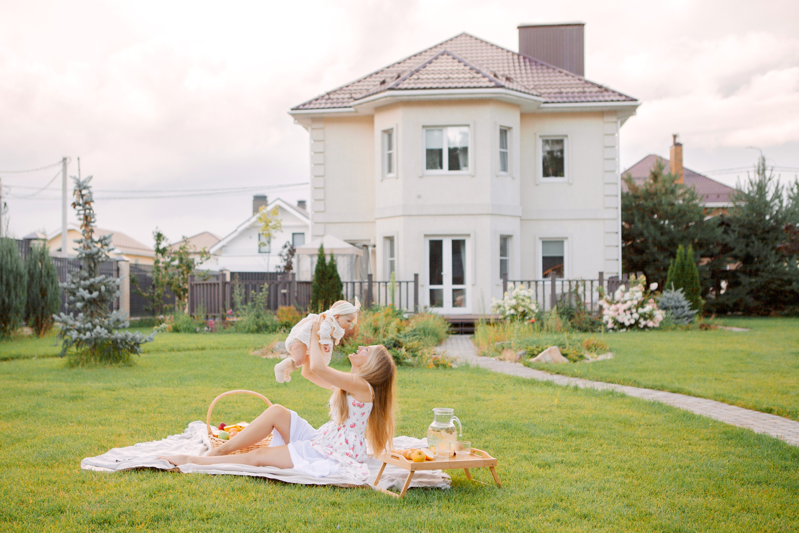 блондинка с дочкой на фоне своего дома. Жизнь мечты.