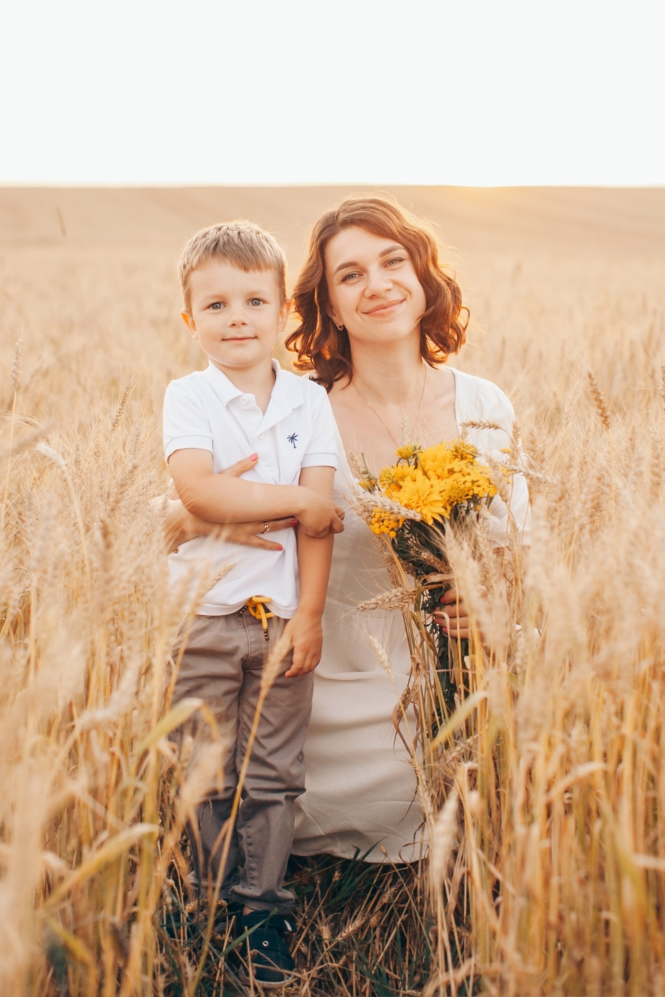 мама с сыном и с букетом полевых цветов на природе