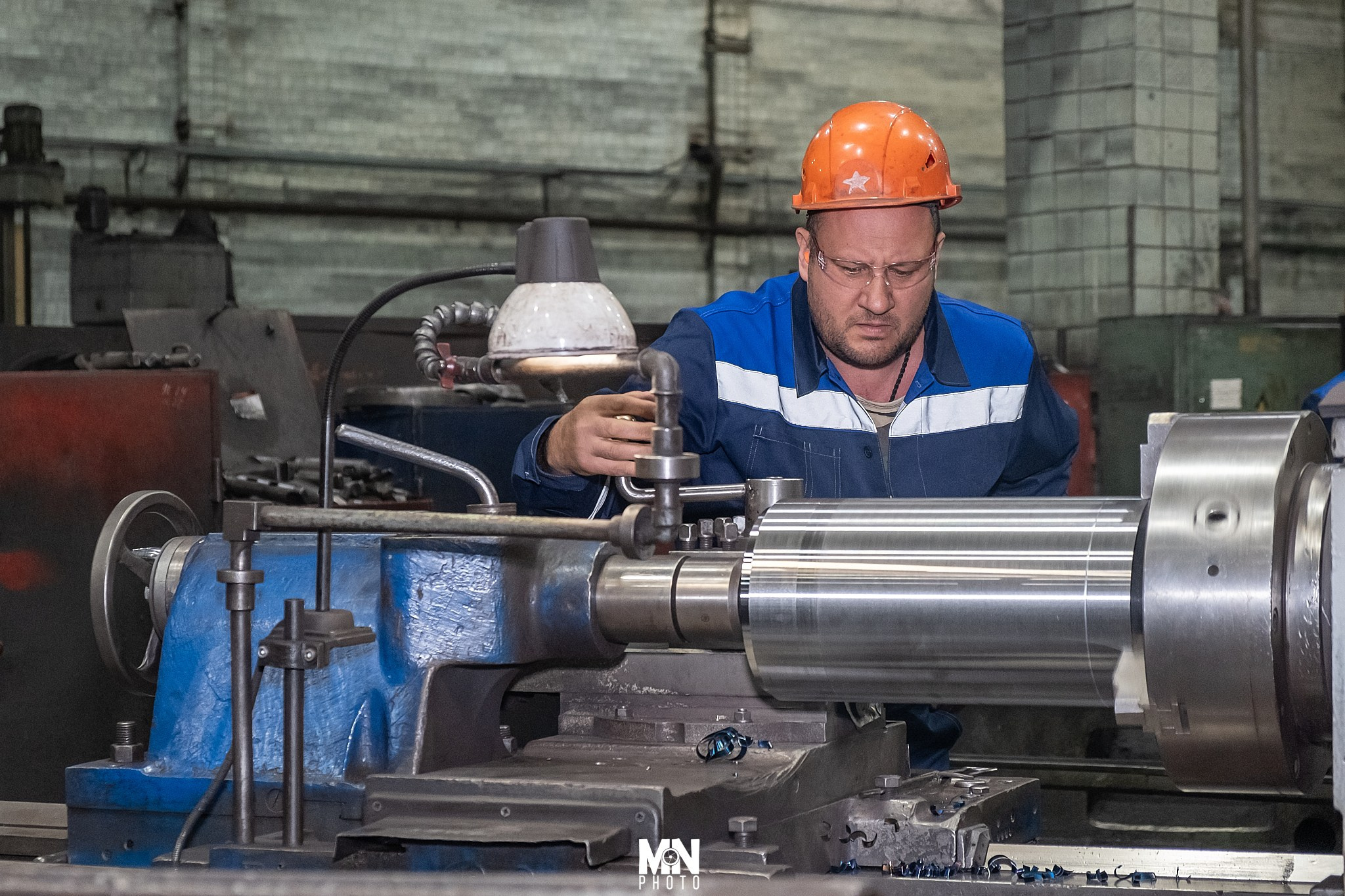 Работник в защитных очках контролирует процесс фрезеровки. Фотограф Никита Максимов. Междуреченск.