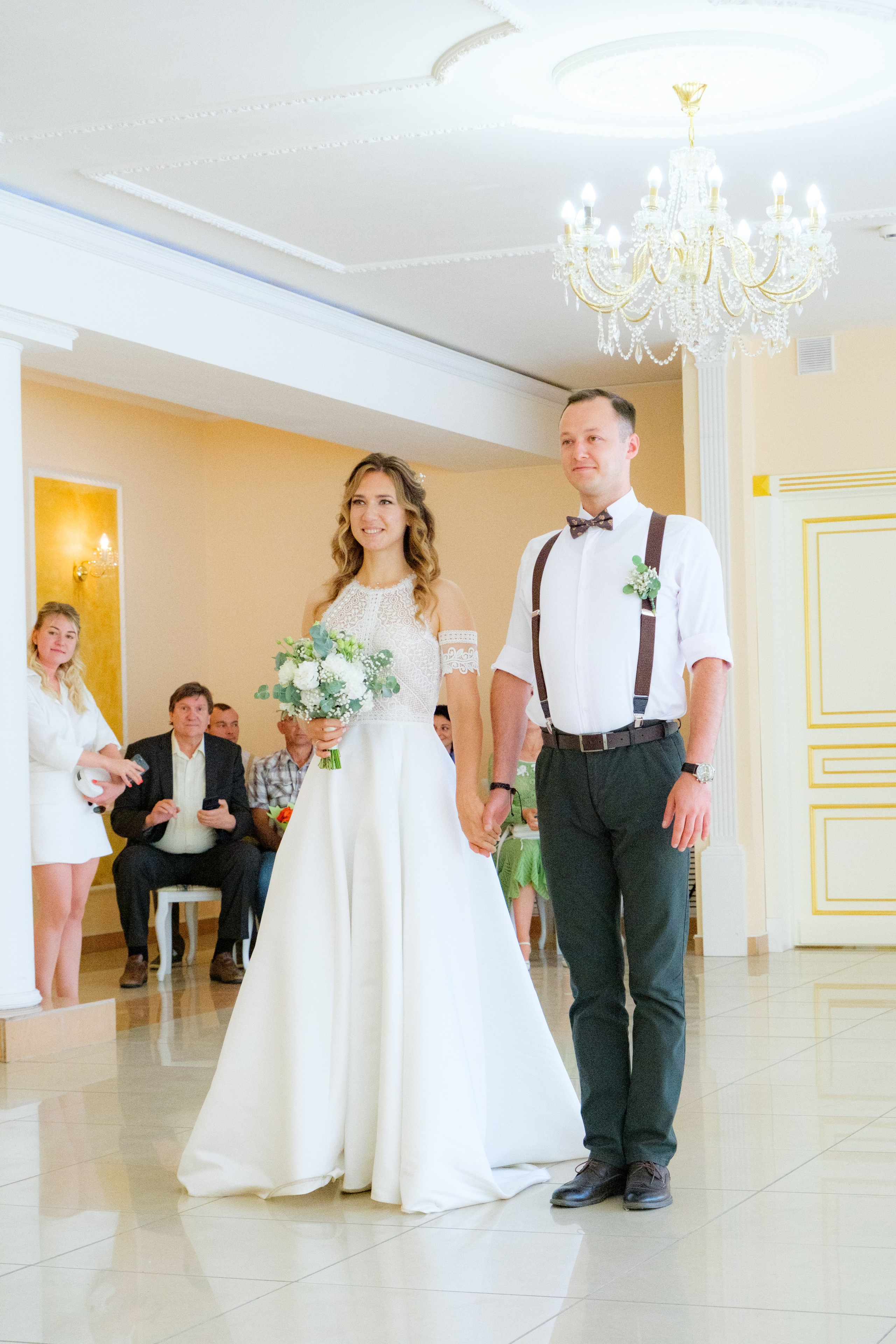 Церемония регистрации брака: молодожены стоят перед регистрационным столом, обмениваясь взглядами полными любви и счастья.