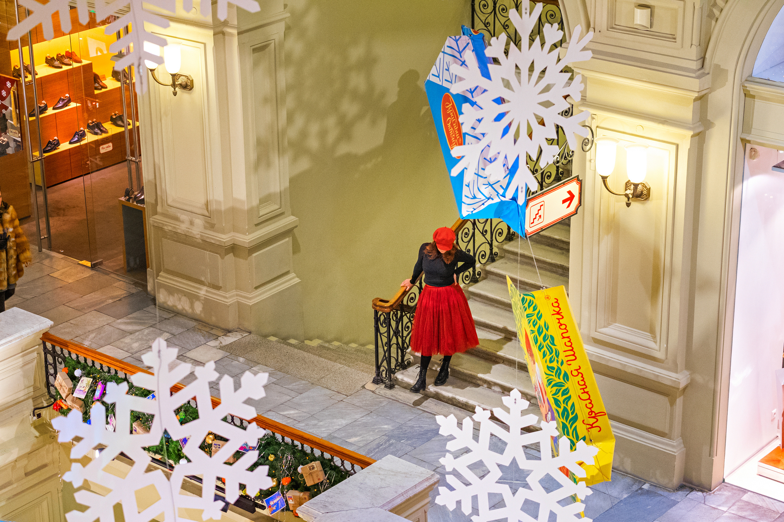 Портретная фотосессия девушки в ГУМ на лестнице в красном берете и красной юбке