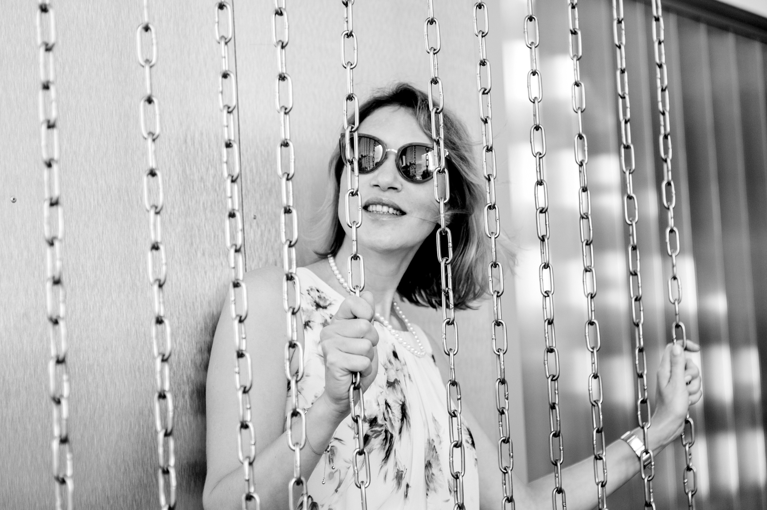 Портретная фотосессия женщины в черно-белом исполнении между декоративных цепей