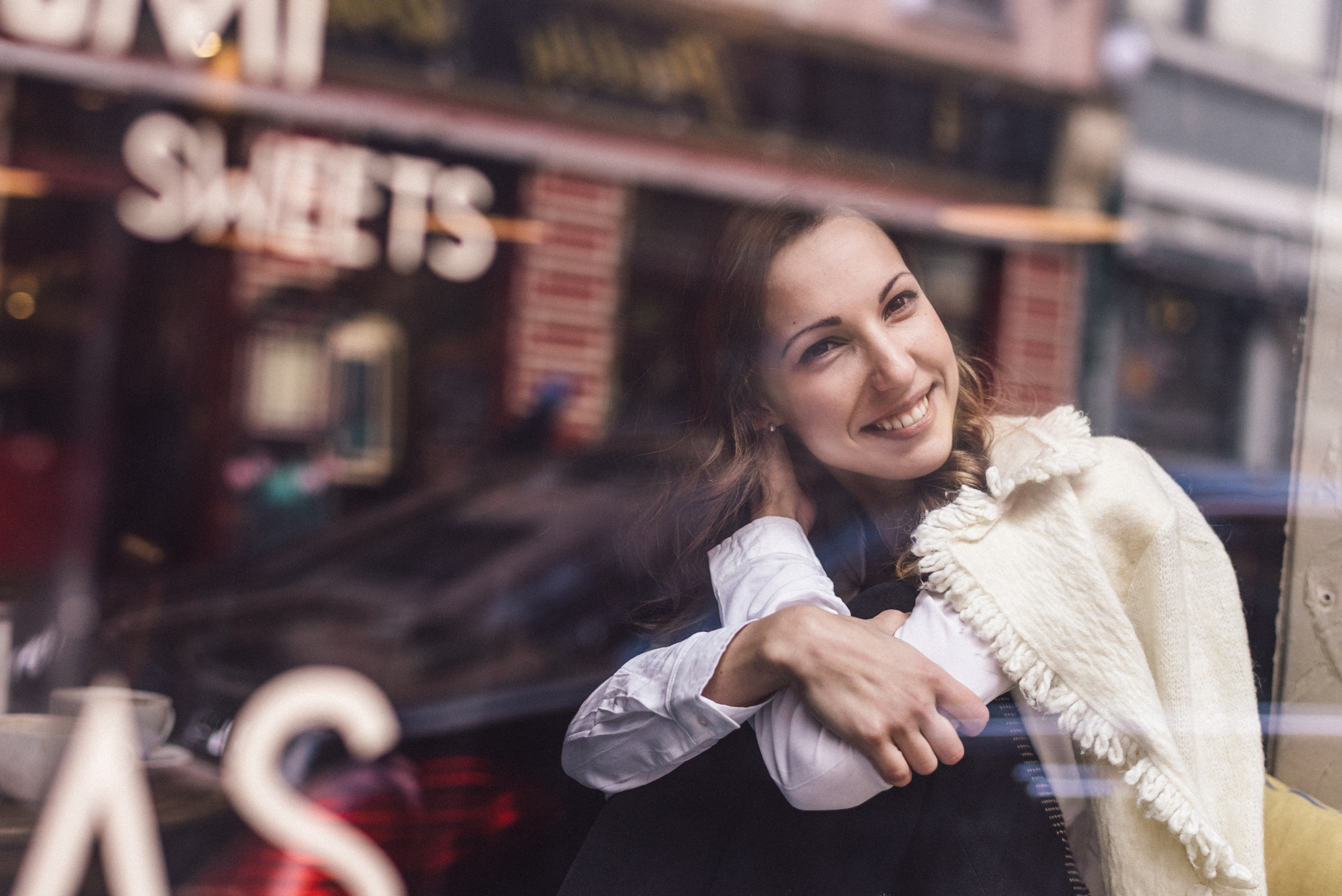 Портретная фотосессия девушки через окно кафе