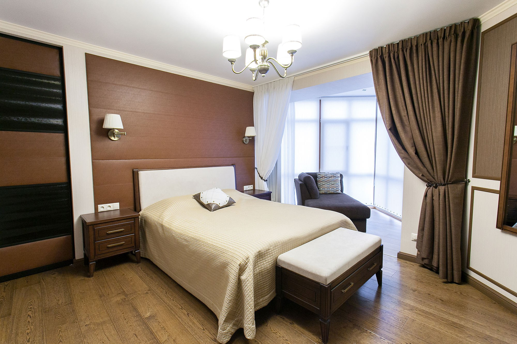 Интерьерная фотография спальни, кровать с текстильным изголовьем и прикроватной тумбой.