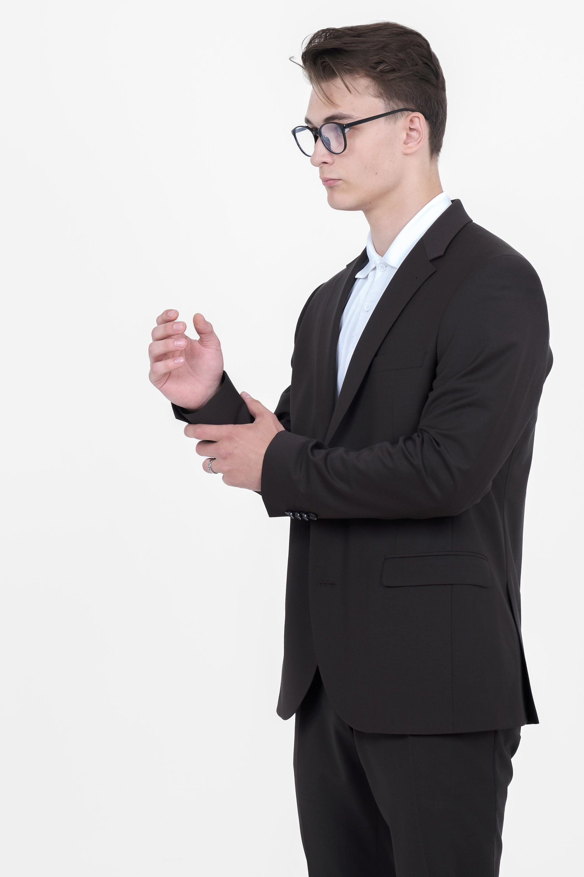 Молодой человек стоит в чёрном костюме и в очках. Фото для маркетплейсов