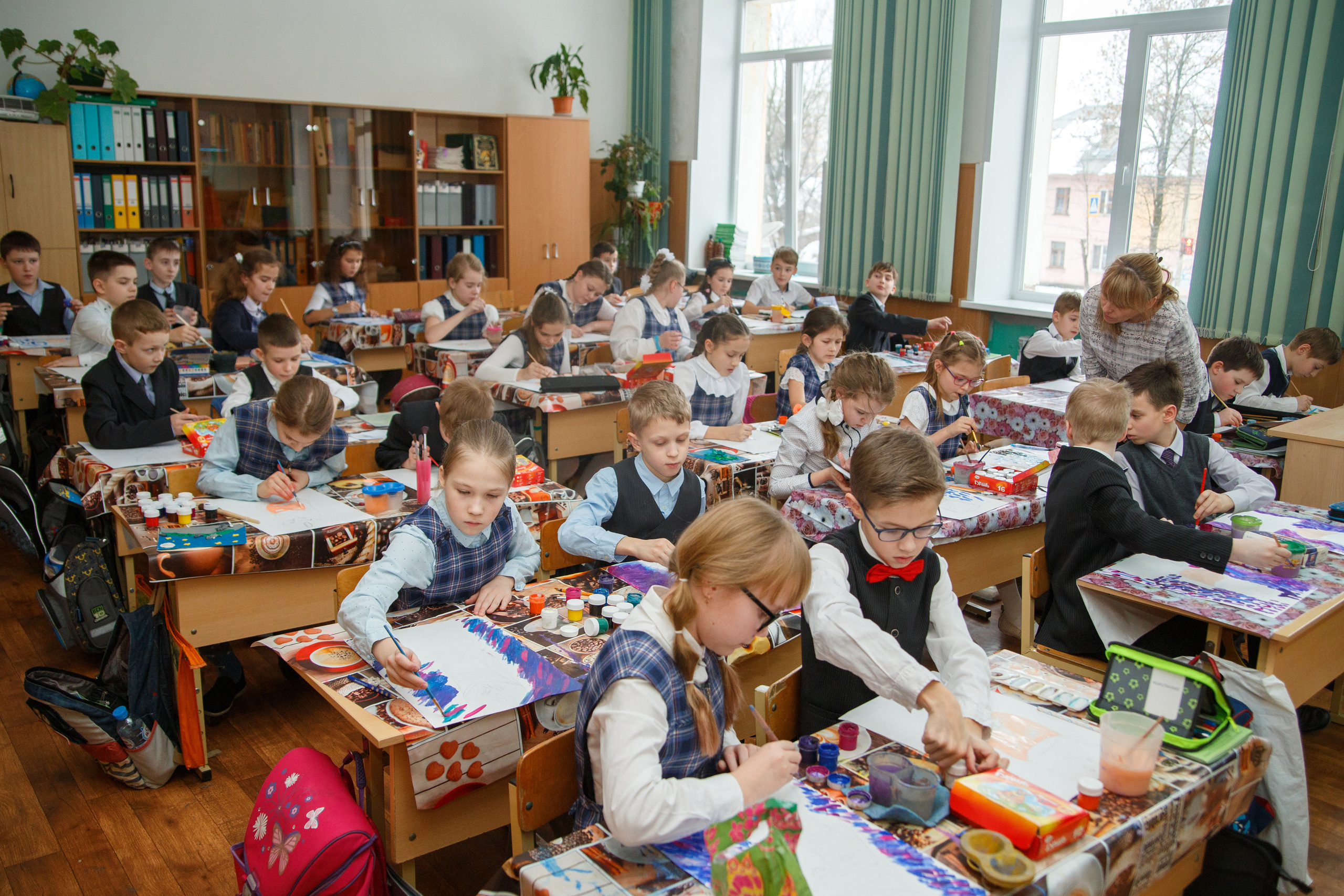 Фотография класса и сидящих за партами учеников во время урока