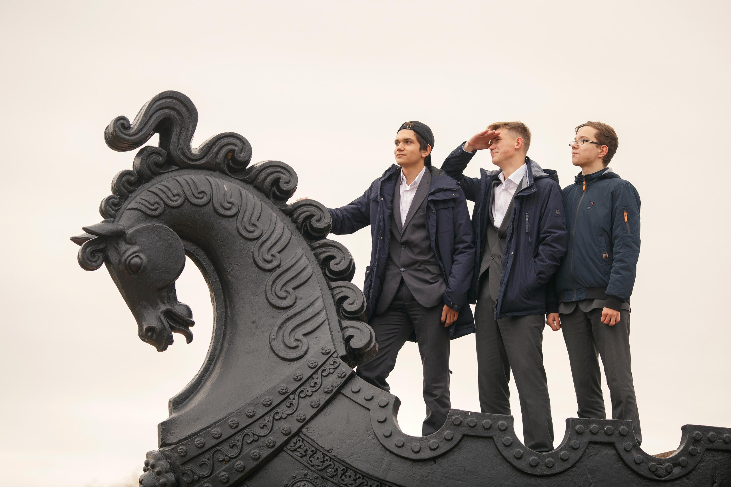 На школьной фотосессии три школьника смотрят вдаль