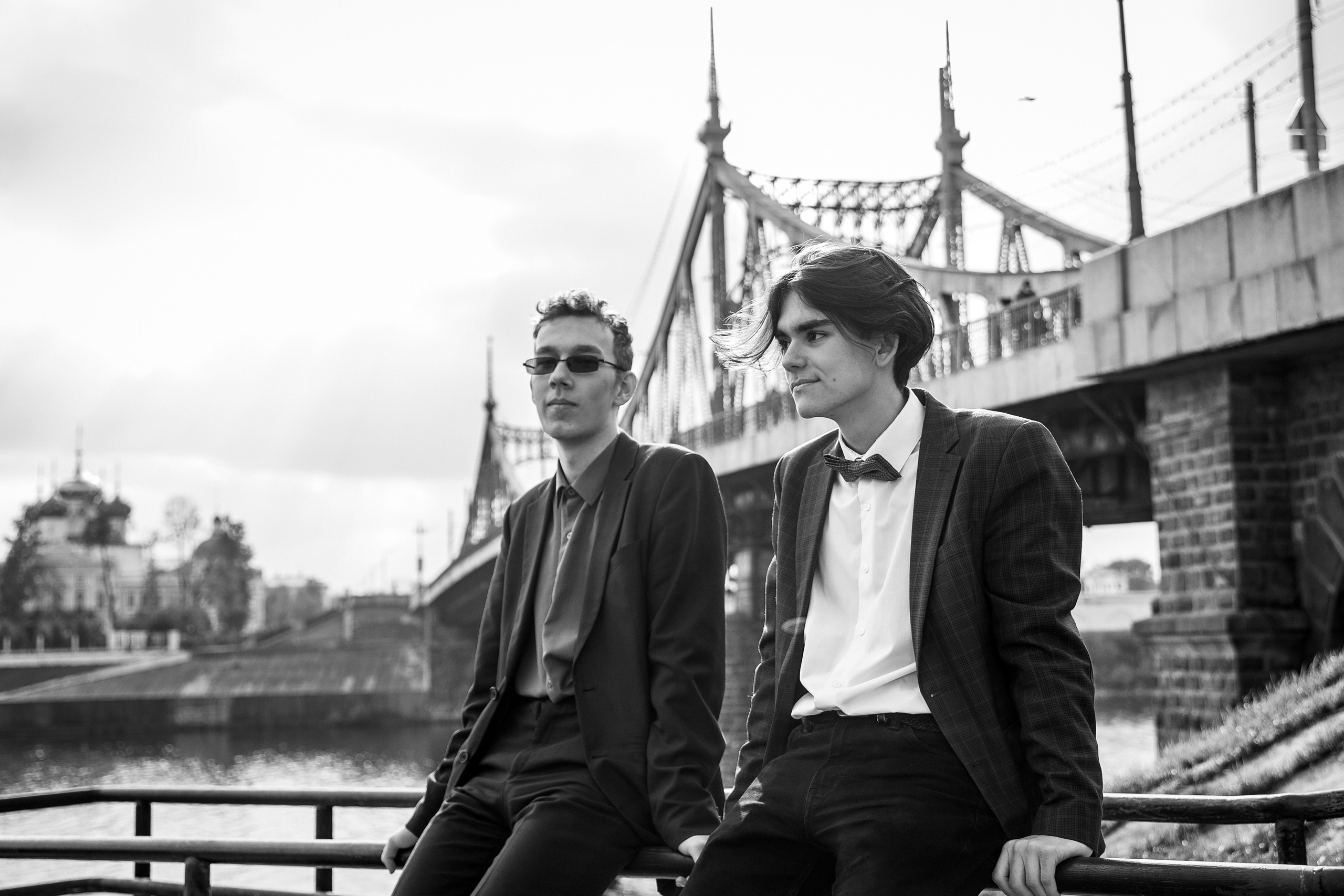 Два выпускника сидят на фоне старого тверского моста