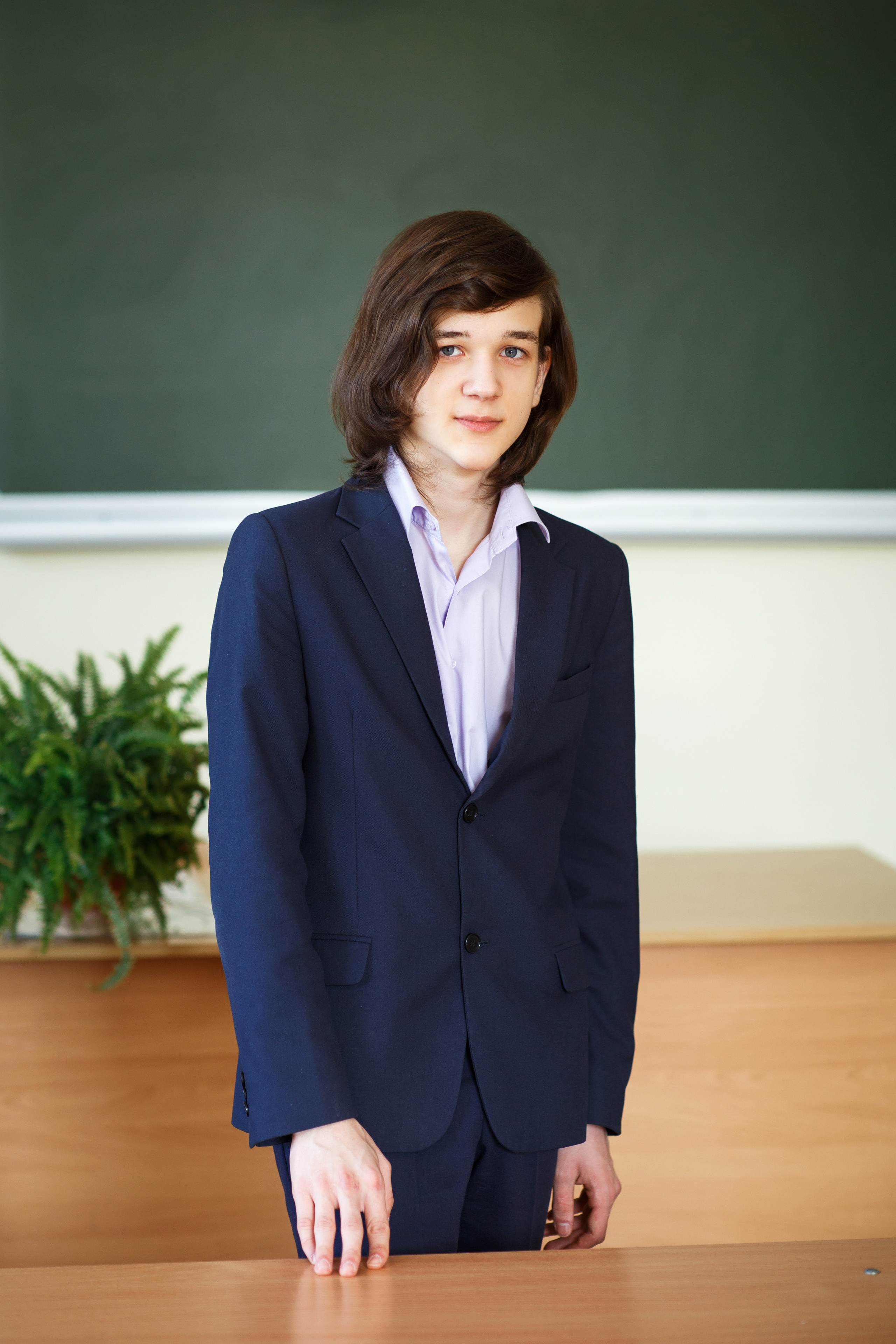 Портрет выпускника в классе на фоне доски