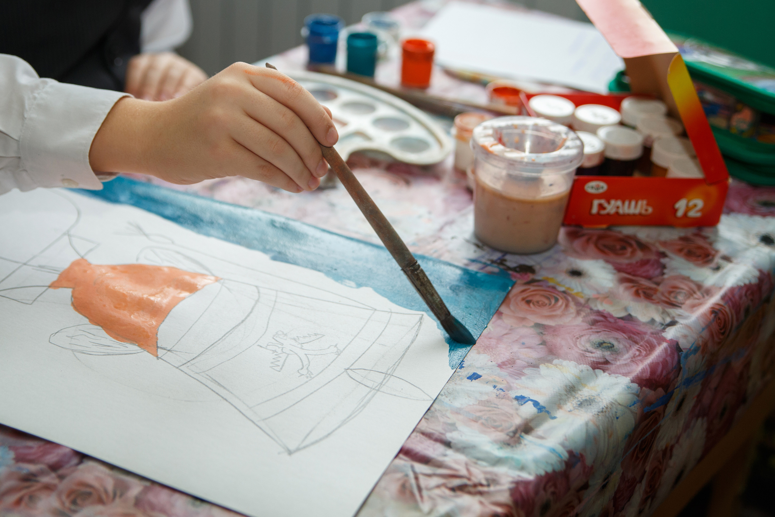 Кисточкой раскрашивают рисунок