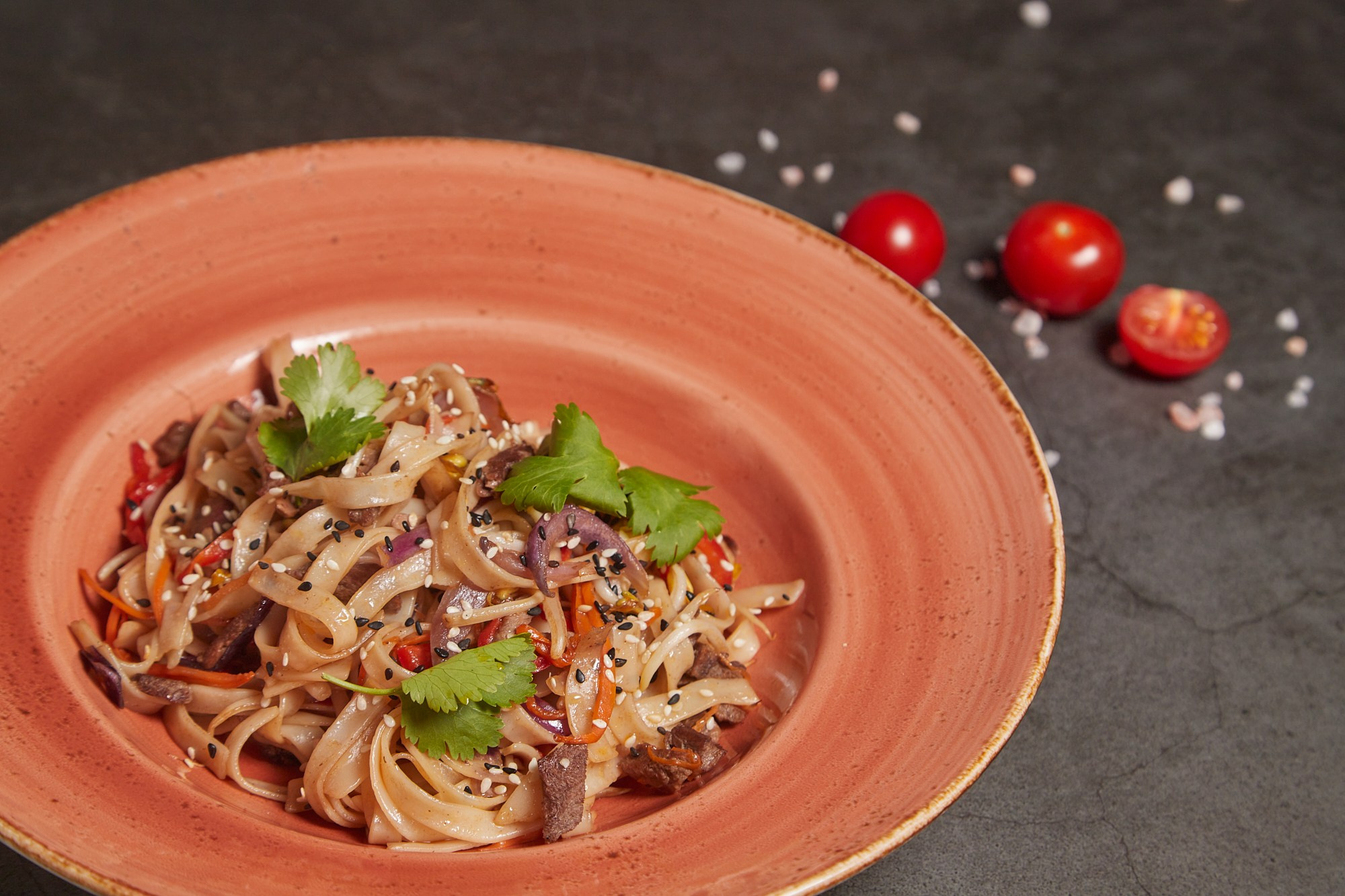 Фуд-фотография пасты с грибами и зеленью в глубокой тарелке.