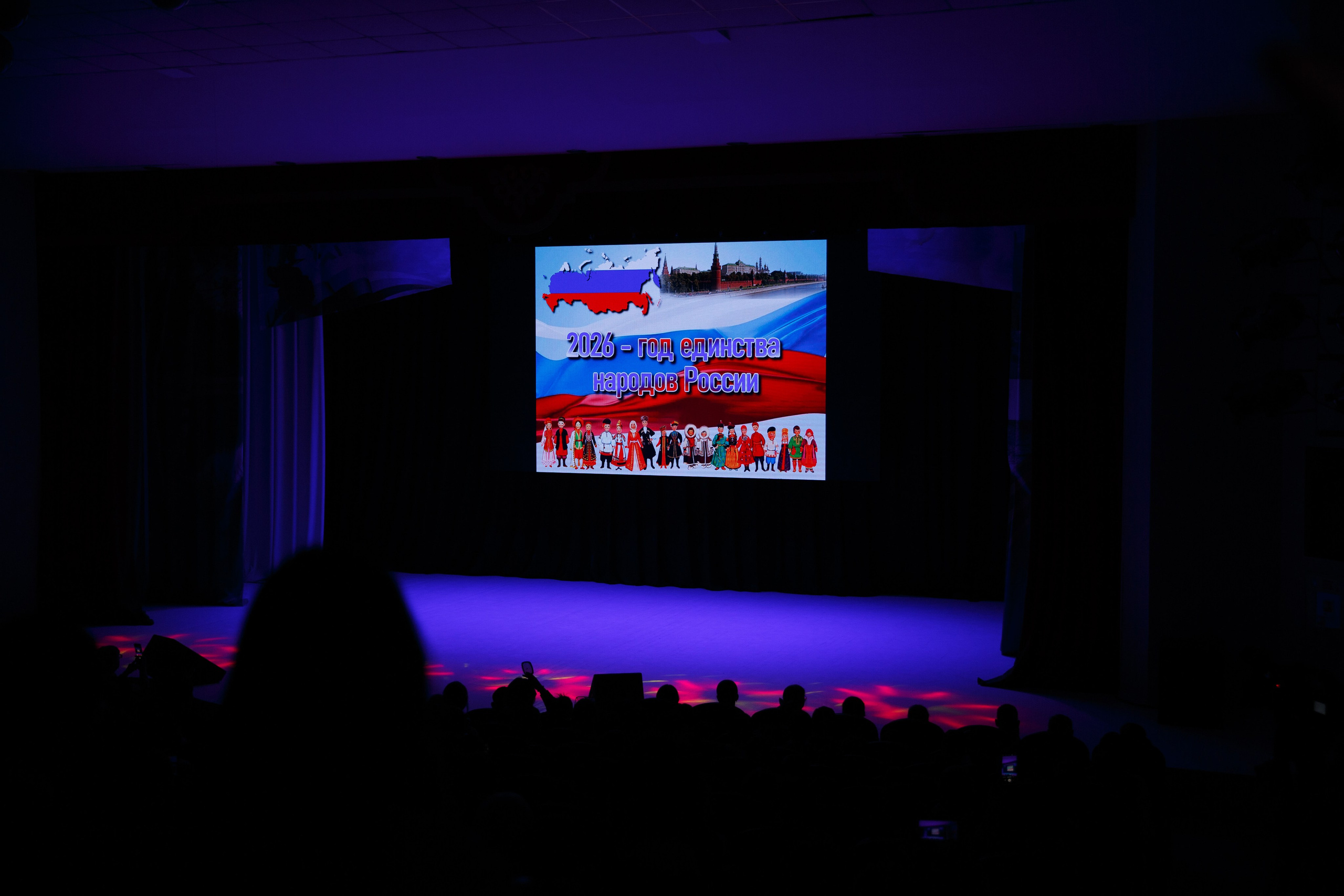 Освещённая сцена в начале спектакля, слайд на экране.
